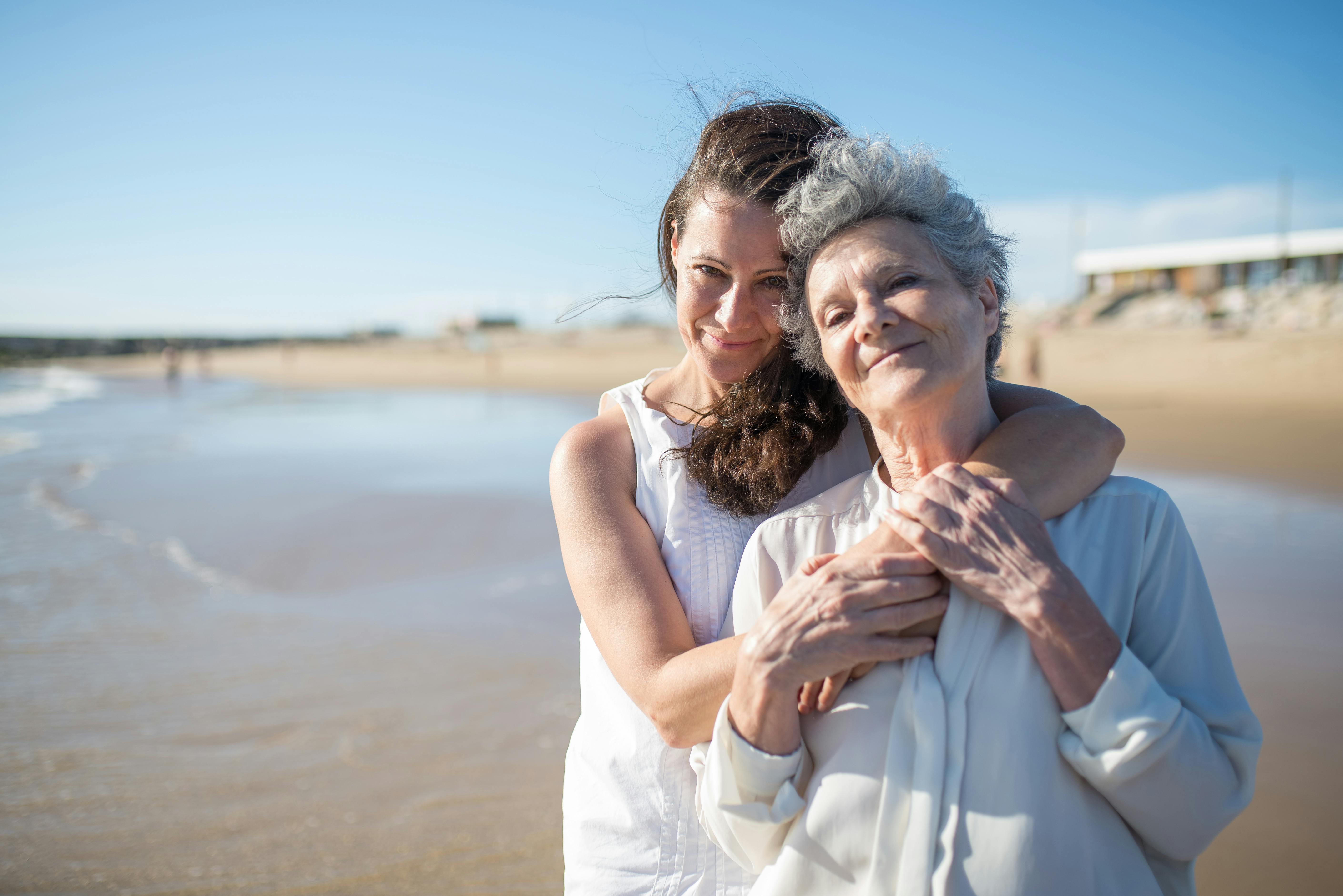 Dos mujeres felices abrazadas en una playa | Fuente: Pexels