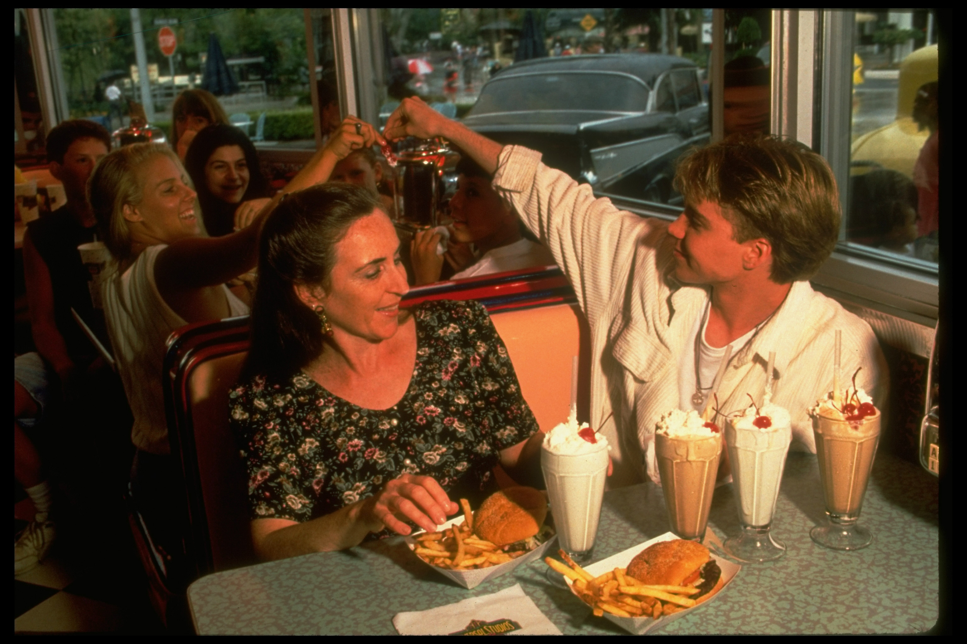 El ídolo adolescente entregando un recuerdo a una fan mientras cenaba con su madre en 1994 | Fuente: Getty Images