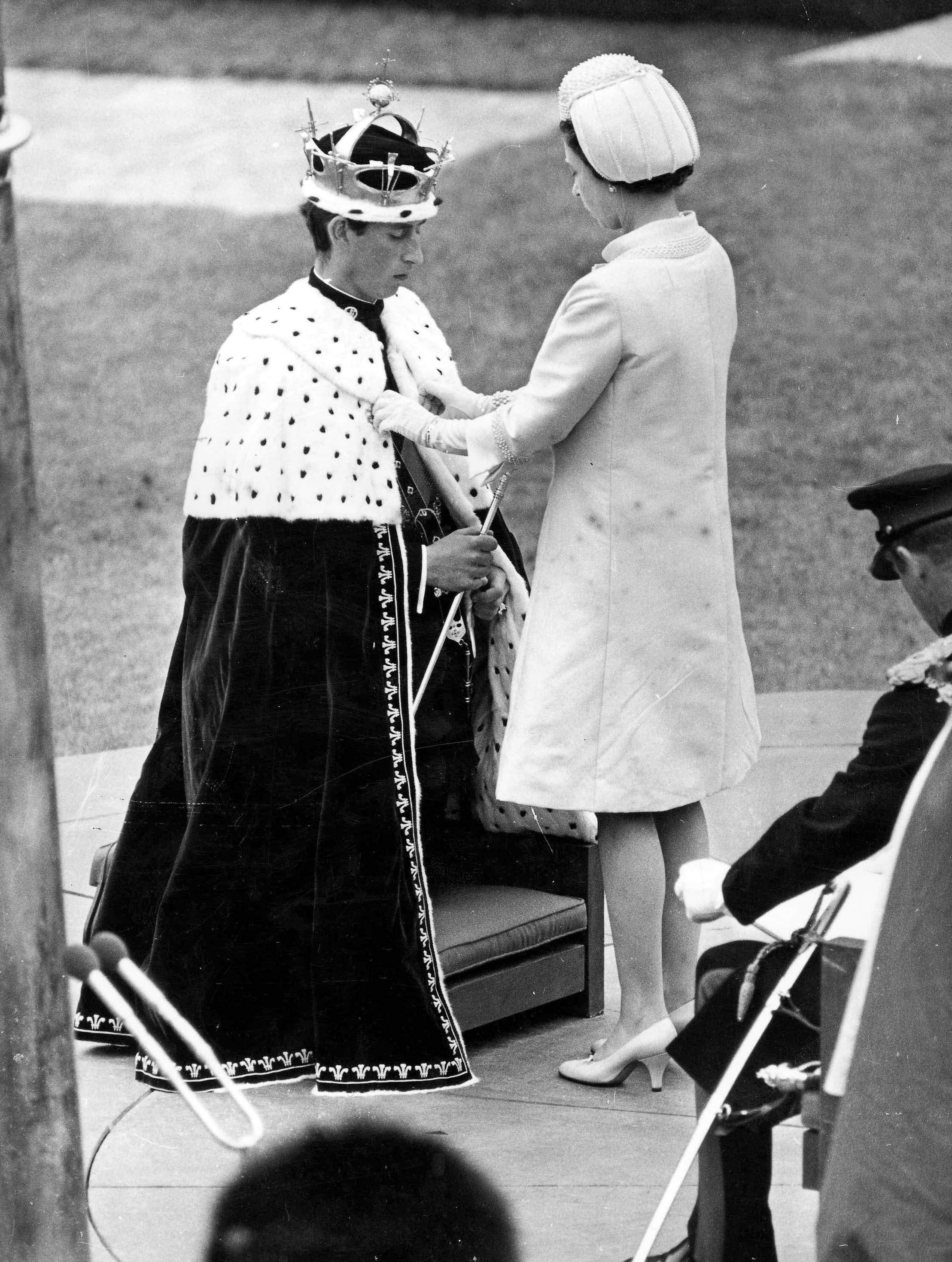 La reina Elizabeth II colocó el manto de armiño sobre los hombros del príncipe Carlos en el castillo de Caerarvon, durante la investidura del príncipe Charles como príncipe de Gales, en julio de 1969 | Foto: Getty Images