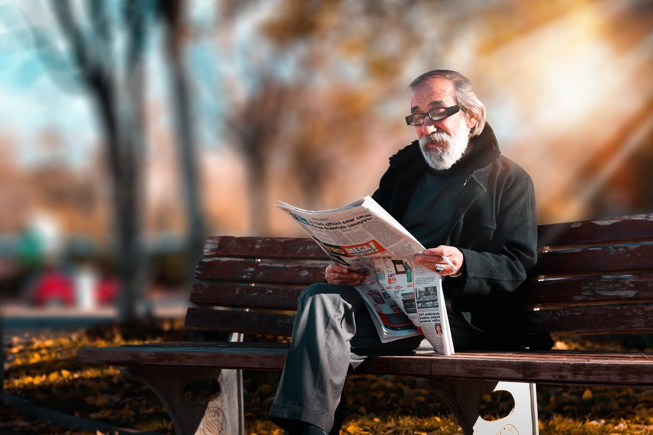 Anciano leyendo un periódico. | Foto: Pexels