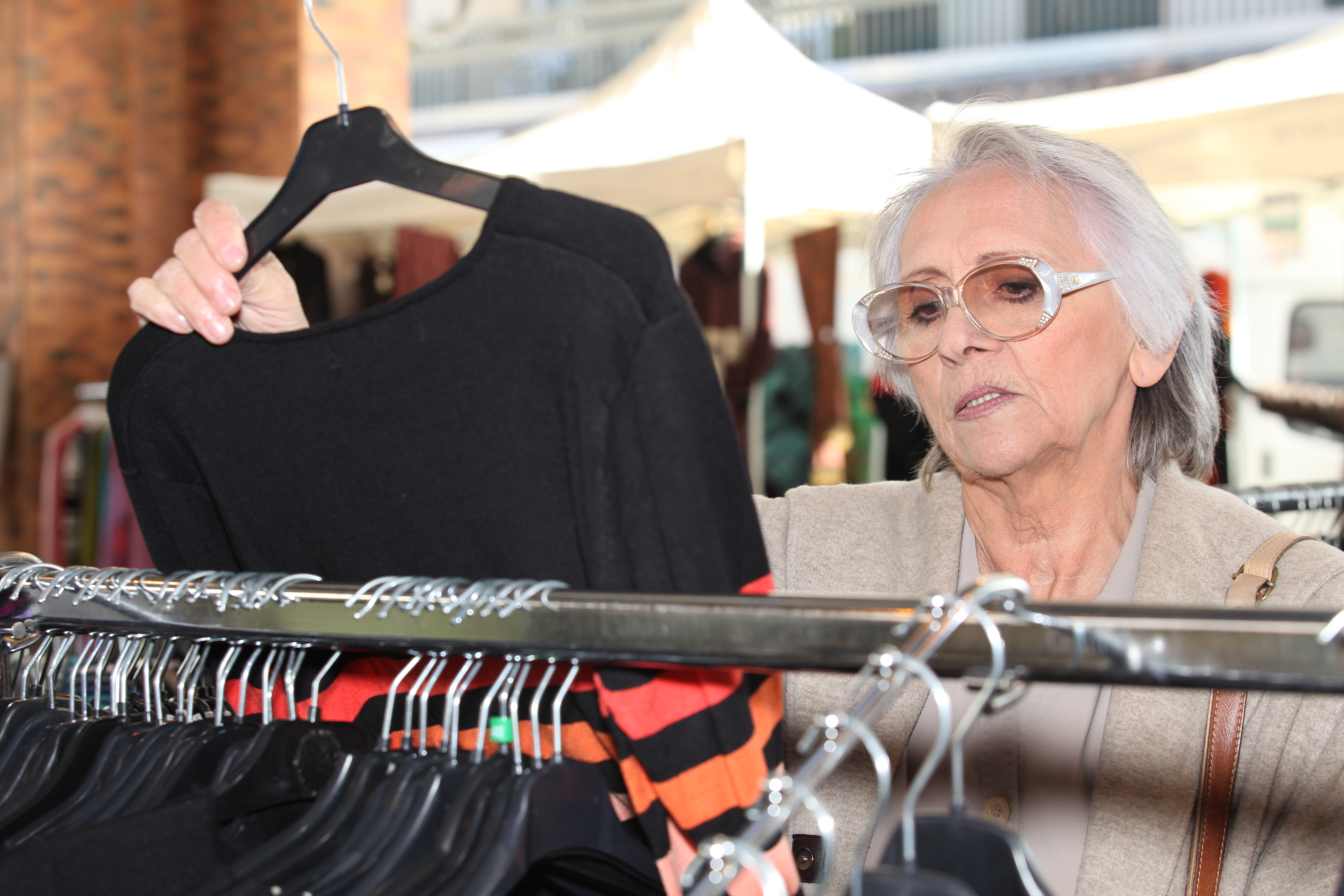 Mujer mayor mira un vestido en la tienda | Foto: Shutterstock