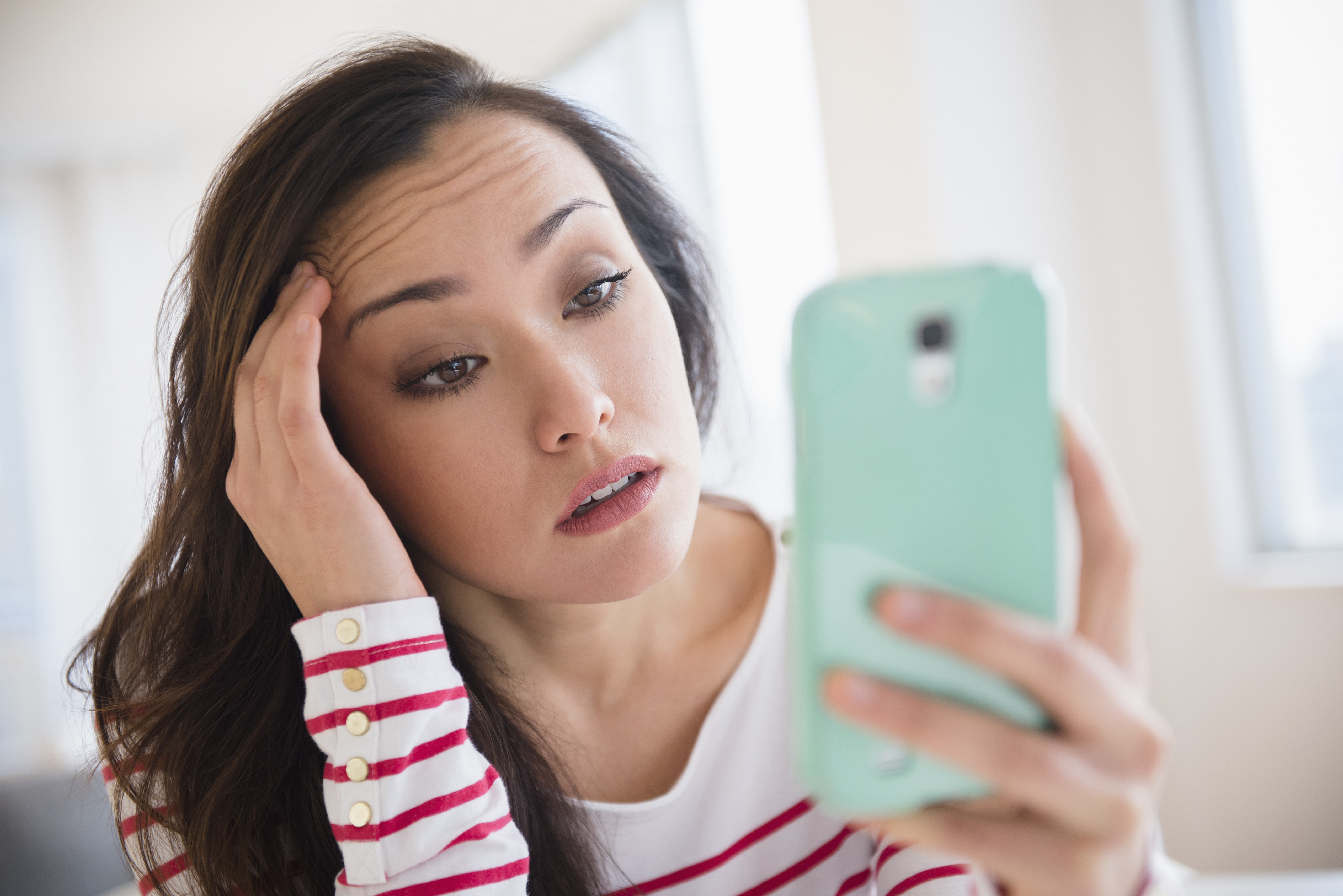 Joven estresada mirando su teléfono. | Foto: Getty Images