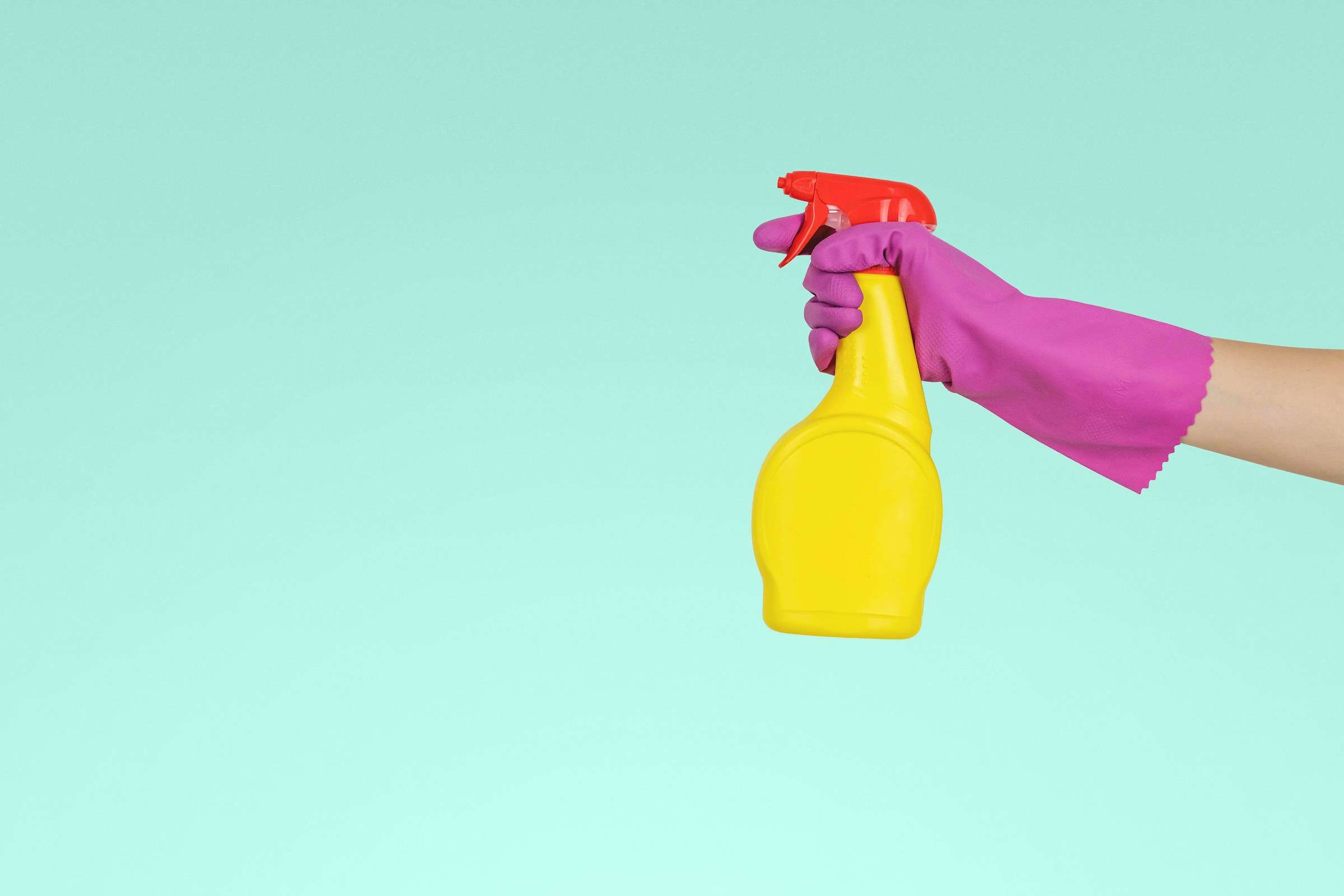 Una persona con una botella de spray amarilla | Foto: Unsplash