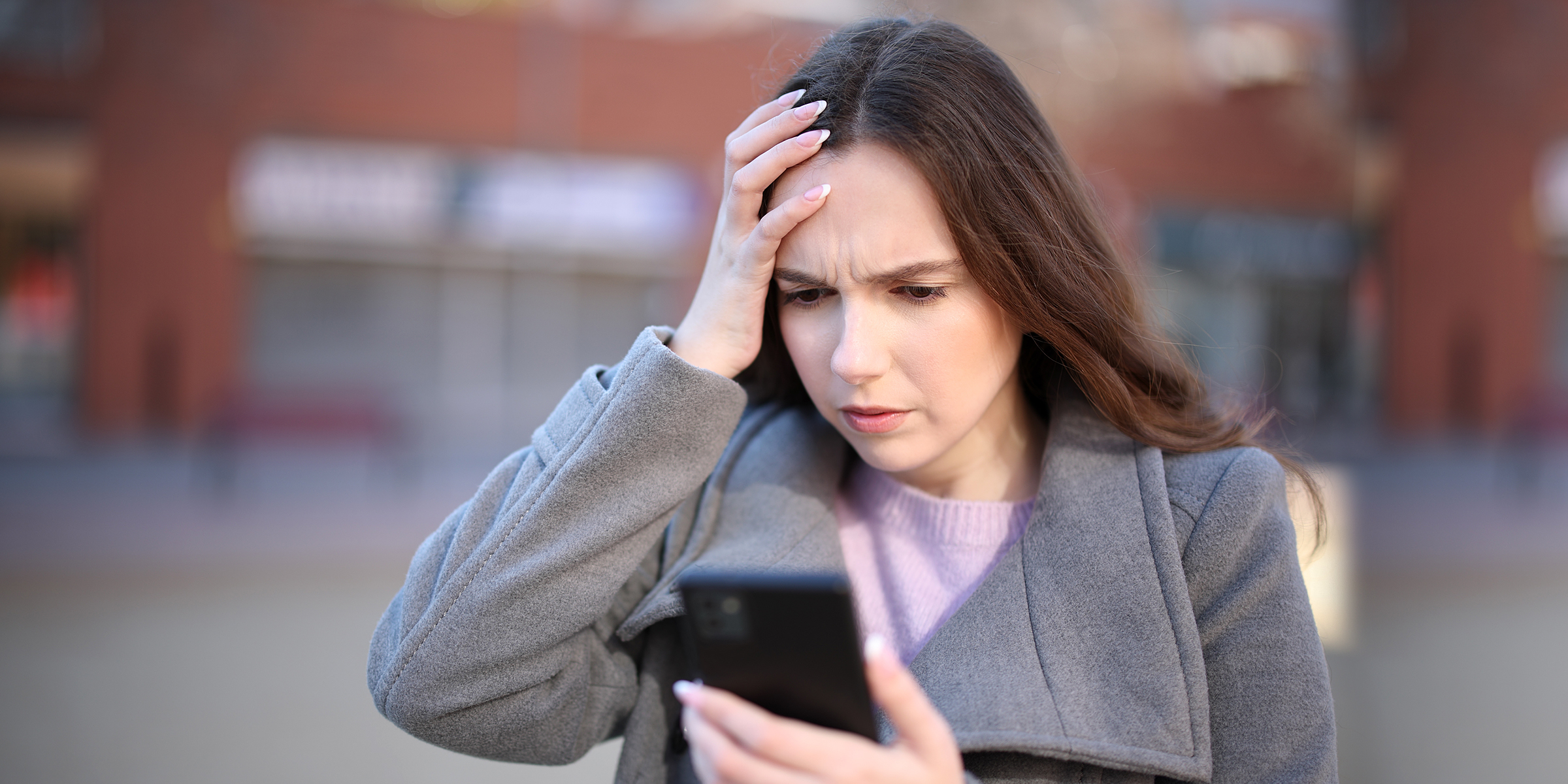 Una mujer conmocionada mirando su teléfono | Fuente: Shutterstock