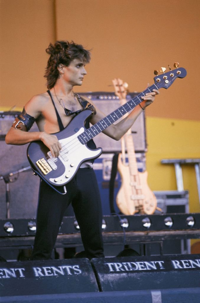 Nacho Cano, músico tocando el bajo durante un concierto de la banda pop Mecano. | Foto: Getty Images