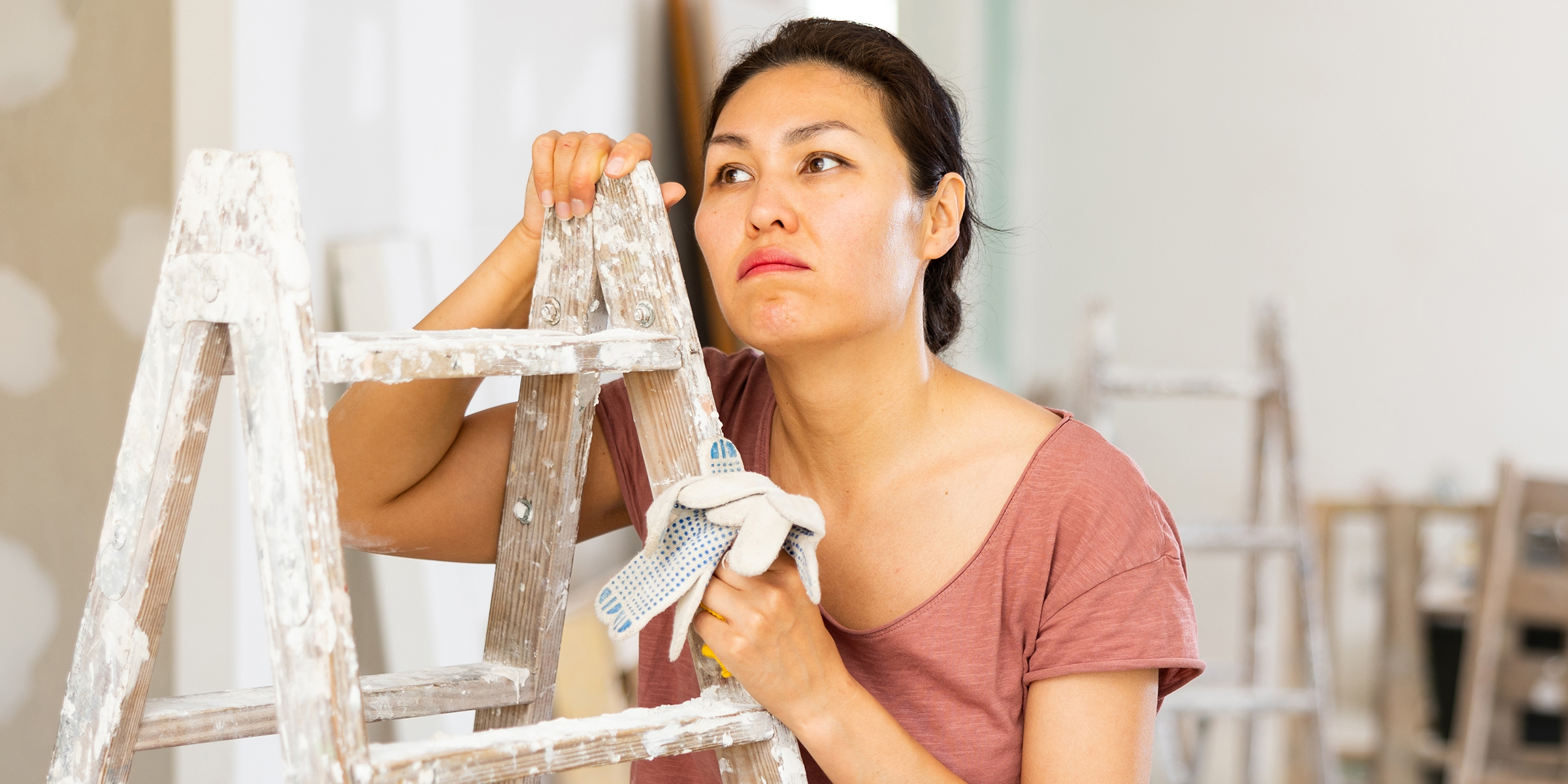 Una mujer sujetando una escalera | Fuente: Shutterstock