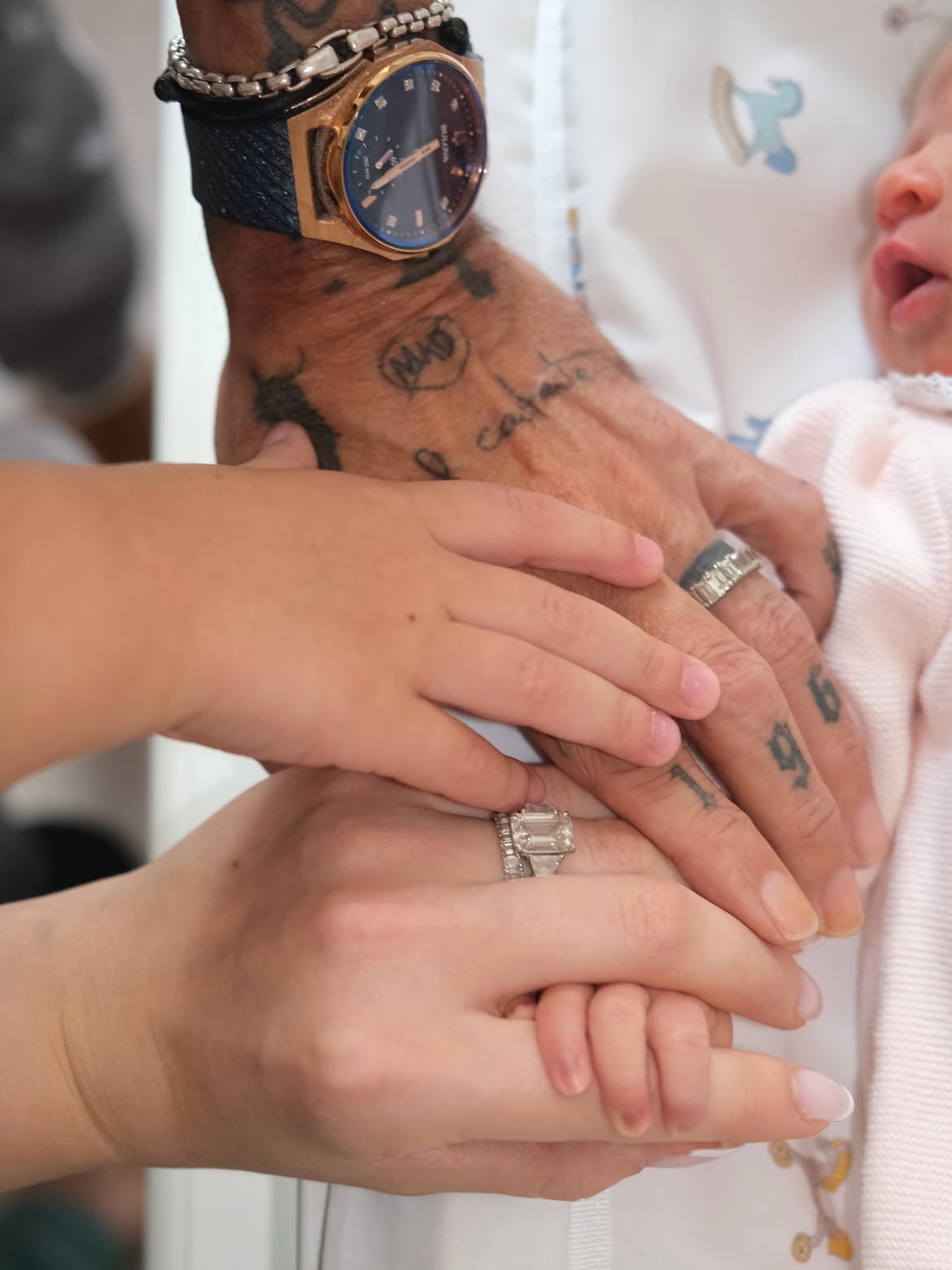 Las manos de Marc Anthony, Nadia Ferreira y su hijo mayor, se apoyan con ternura sobre la manta de la bebé recién nacida | Fuente: Instagram/nadiaferreira