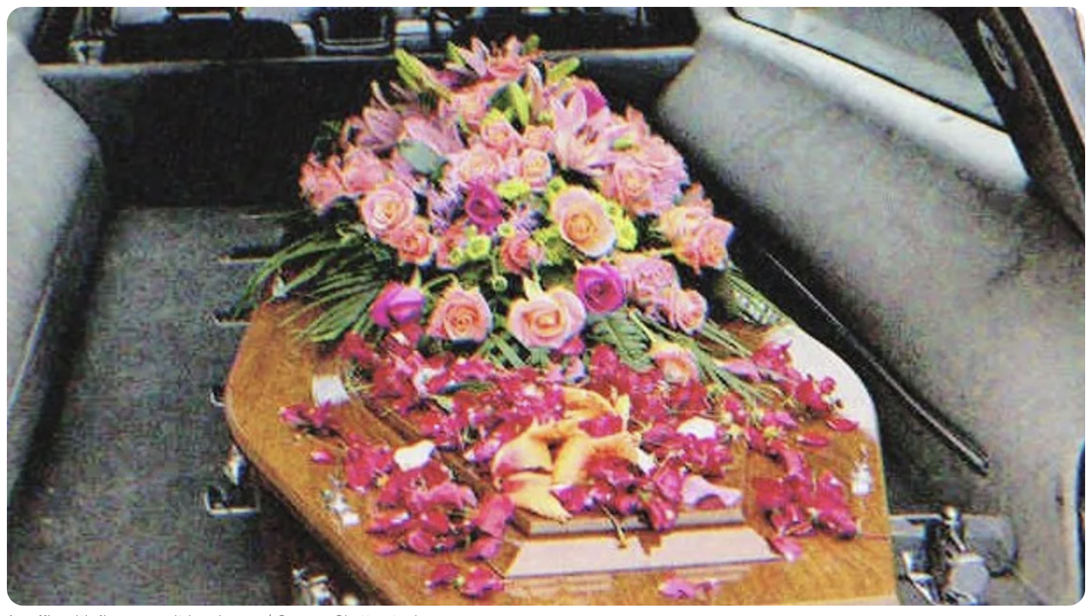 Ataúd con flores en un coche fúnebre | Fuente: Shutterstock