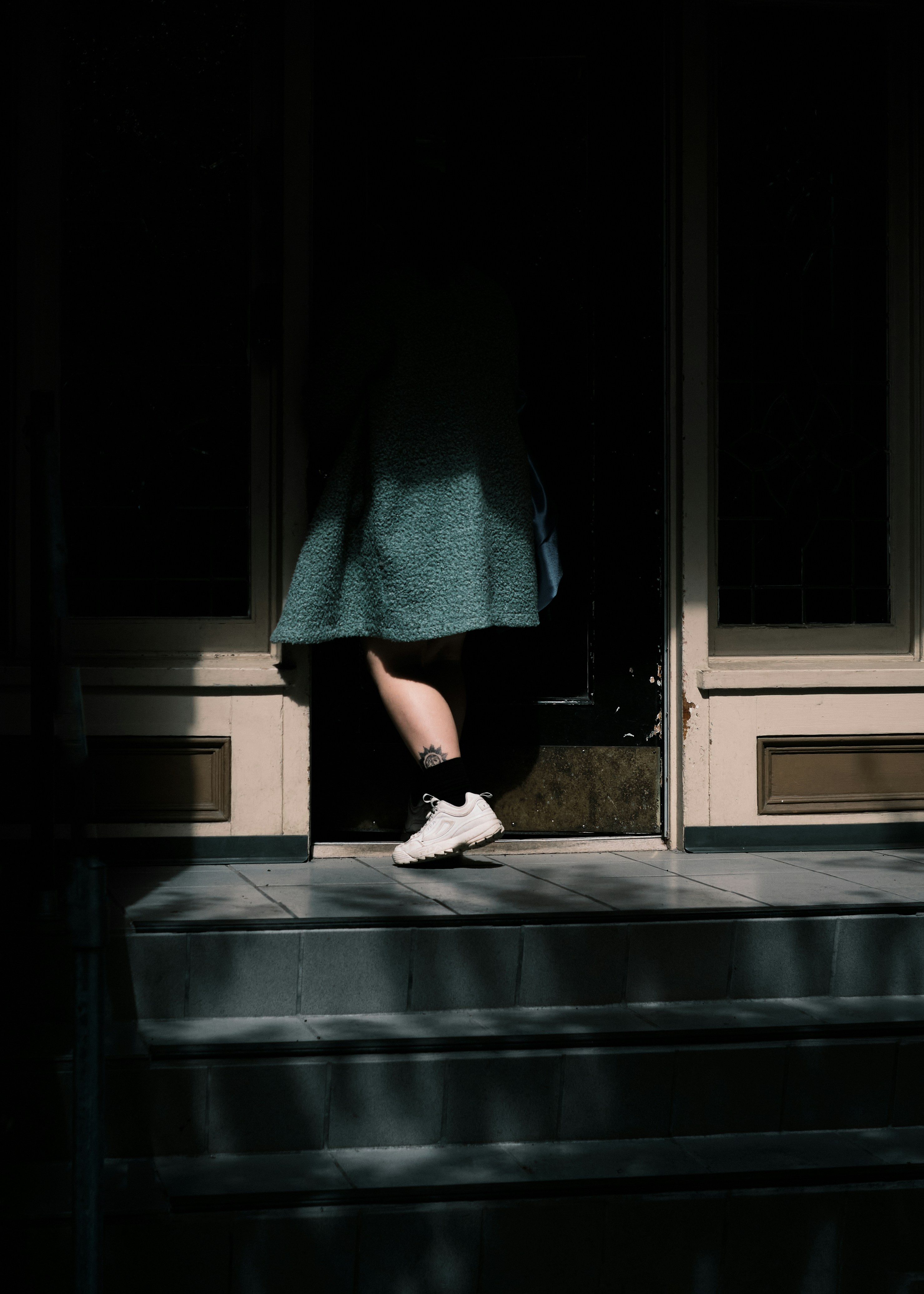 Una mujer saliendo a hurtadillas de una casa por la noche | Fuente: Unsplash