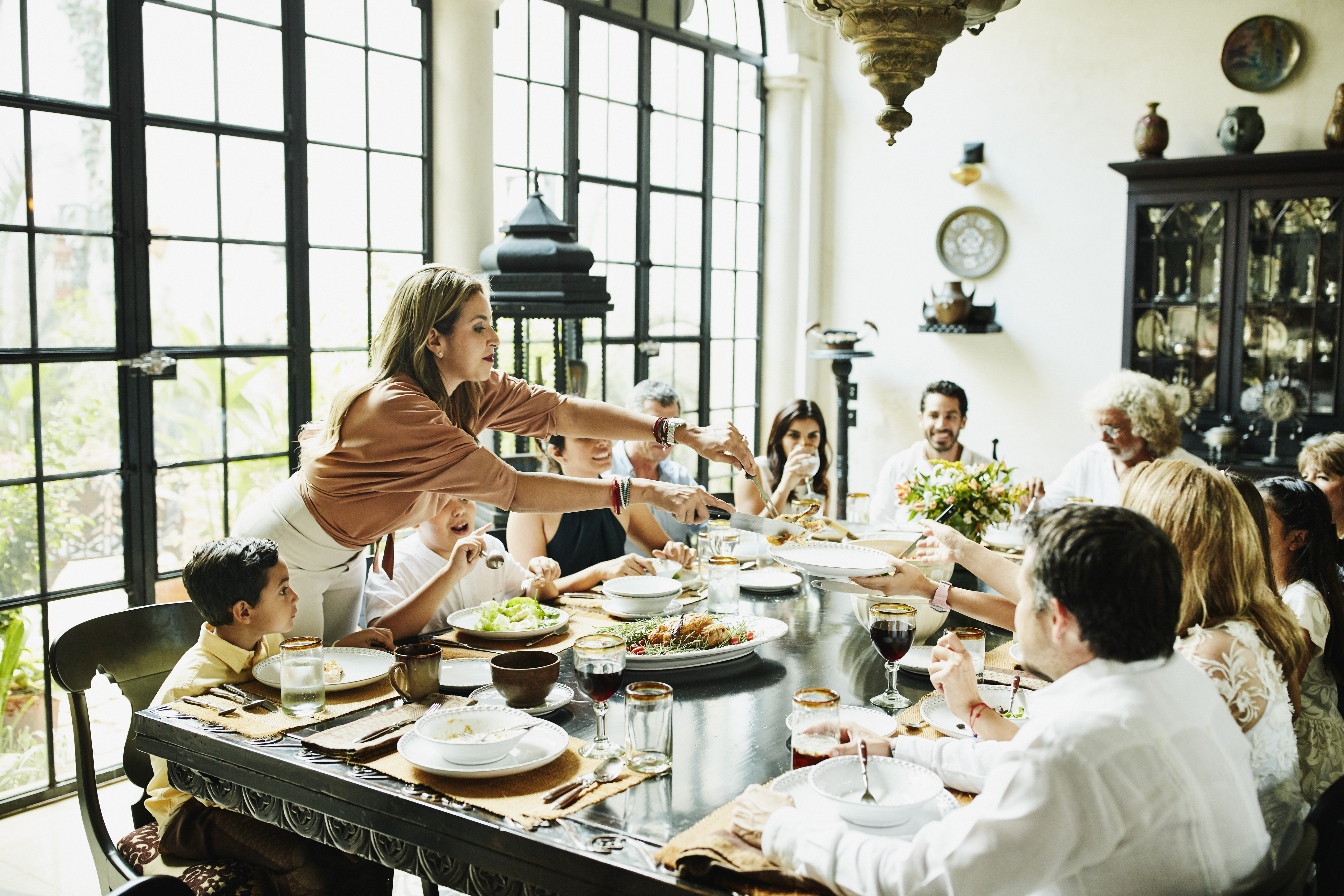 Una familia reunida alrededor de una mesa | Foto: Getty Images