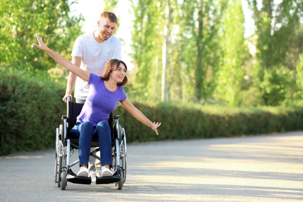 Joven moviliza a chica en silla de ruedas. | Foto: Shutterstock.