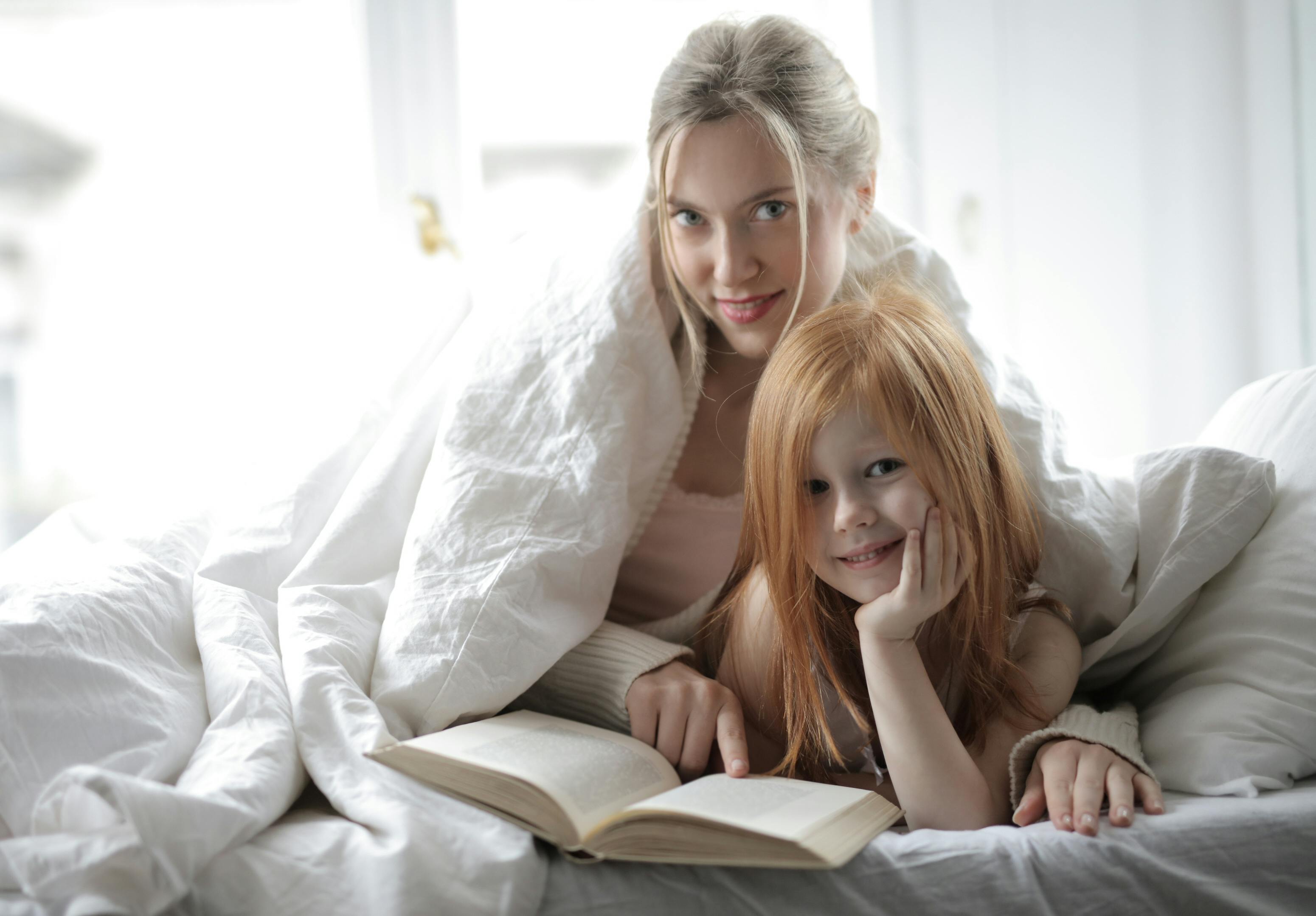 Una madre y su hija leyendo juntas un libro | Fuente: Pexels