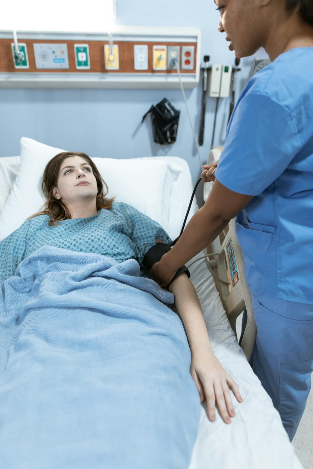 Una mujer en una cama de hospital y una enfermera | Fuente: Pexels