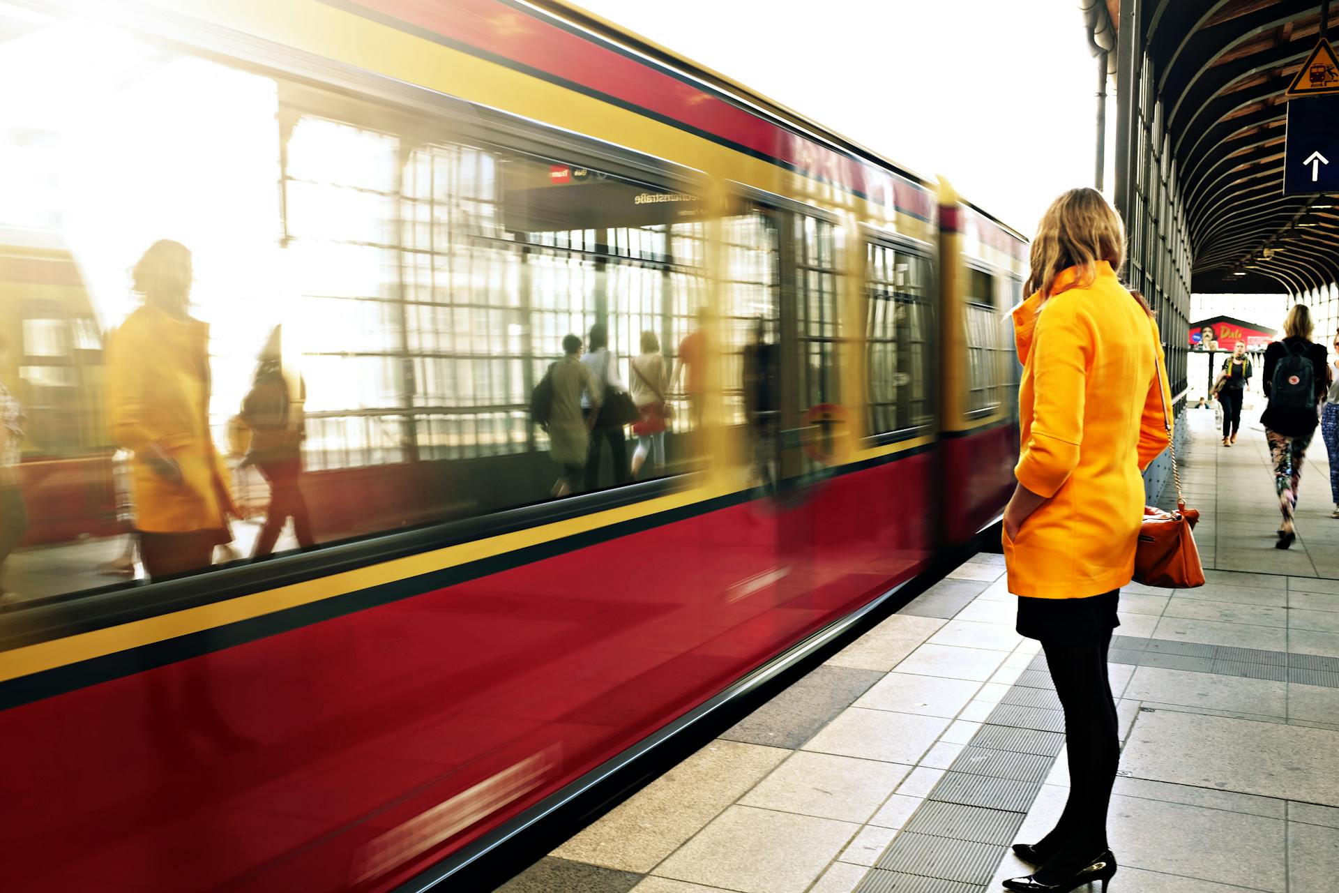 Una mujer junto a un tren rojo | Foto: Pexels