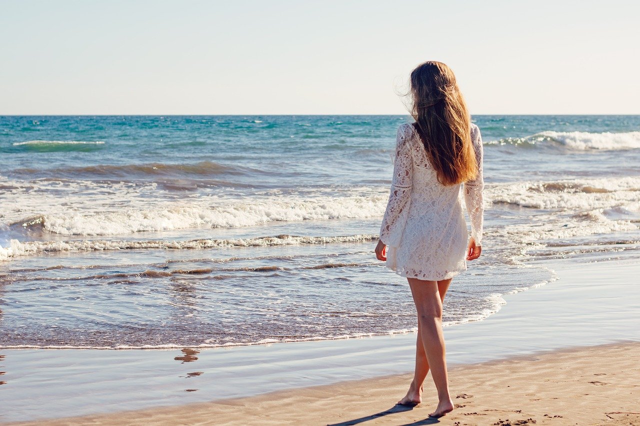 Mujer vestida de blanco en la playa. |  Foto: Pixabay
