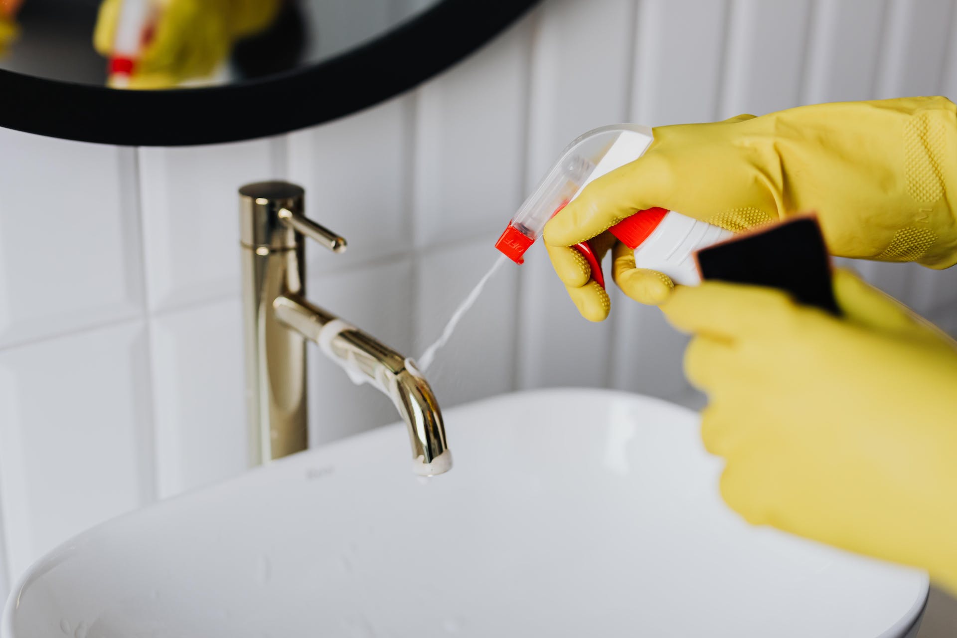 Persona limpiando el baño con guantes amarillos | Foto: Pexels