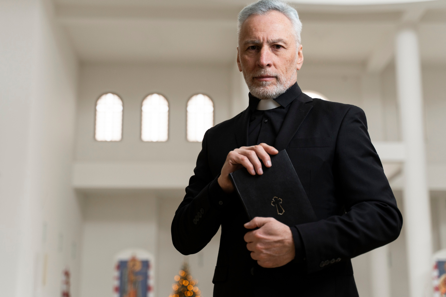 Un sacerdote sosteniendo un libro sagrado | Fuente: Freepik