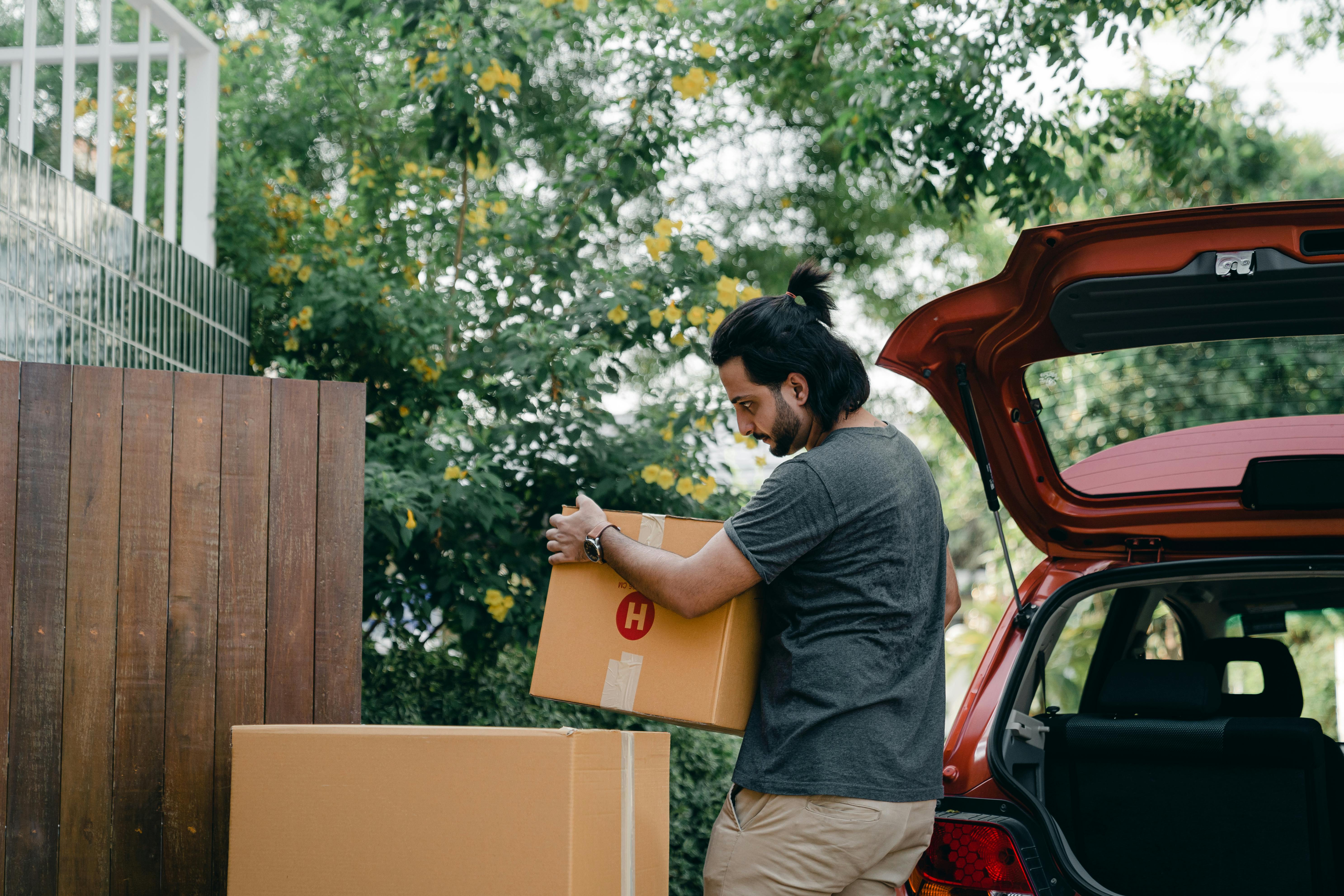 Un hombre metiendo cajas de mudanza en un Automóvil | Fuente: Pexels