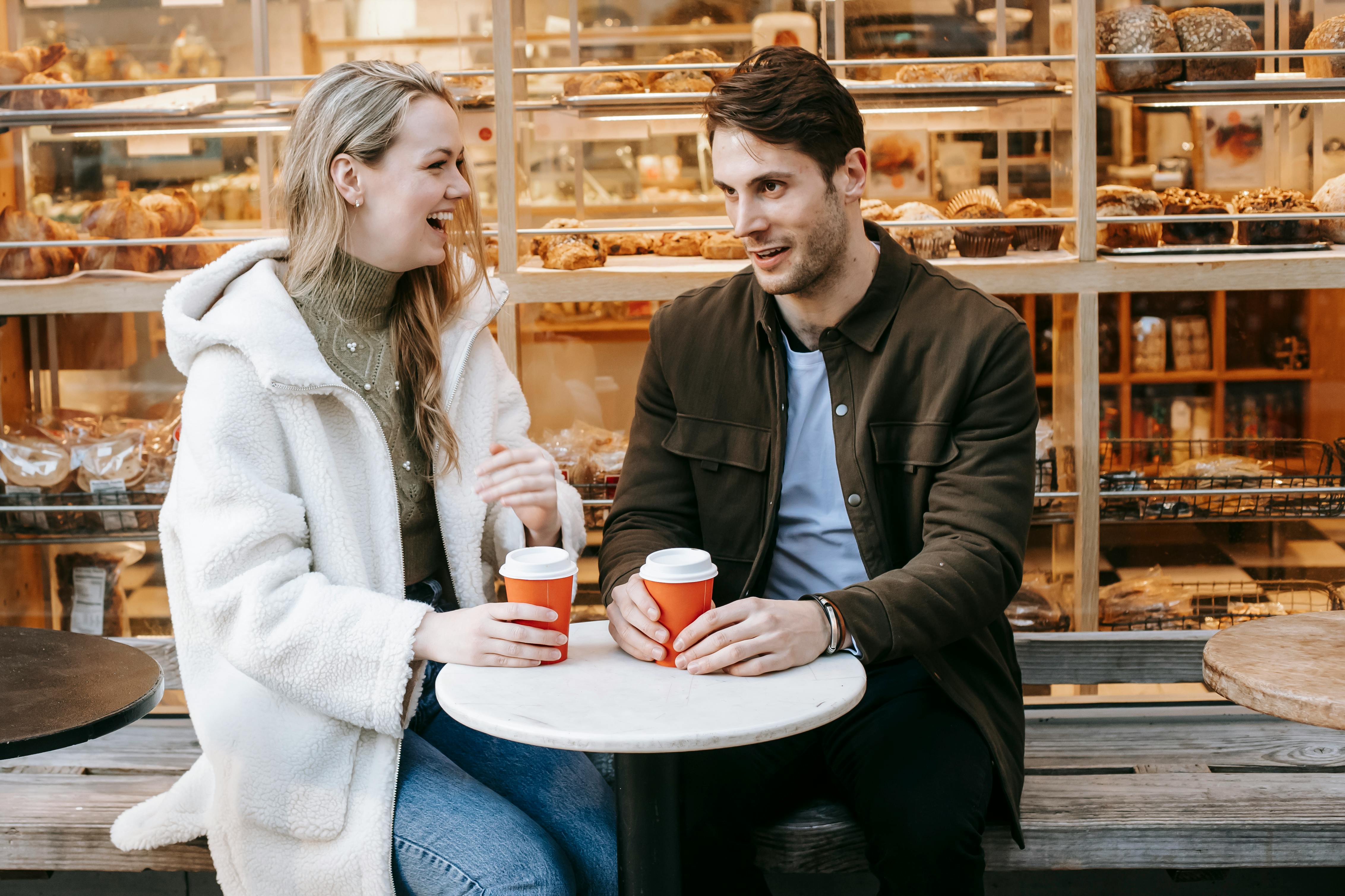 Una pareja feliz tomando café | Fuente: Pexels