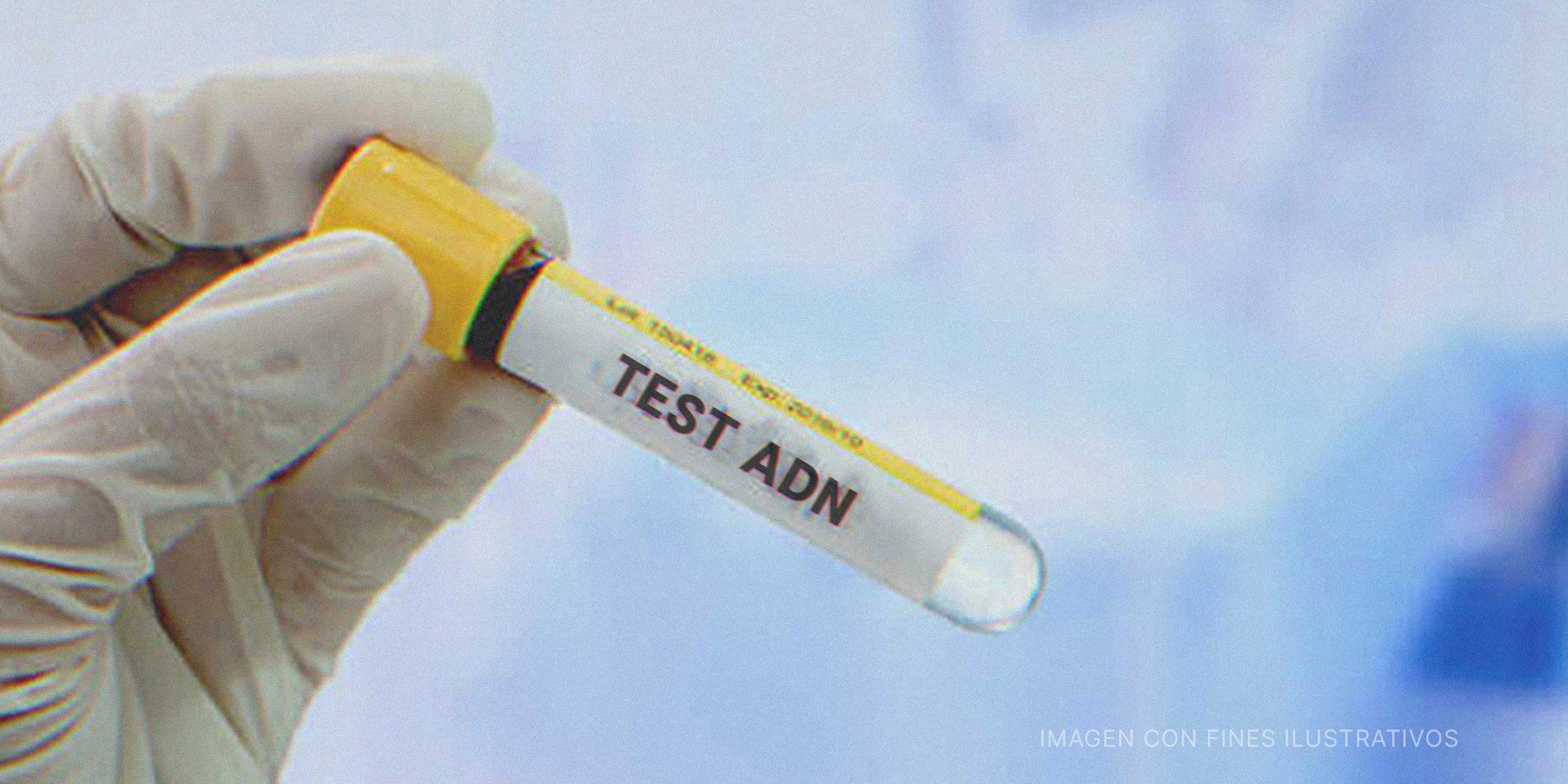 Mano enguantada sosteniendo un vial con "Prueba de ADN" escrito en la etiqueta. | Shutterstock