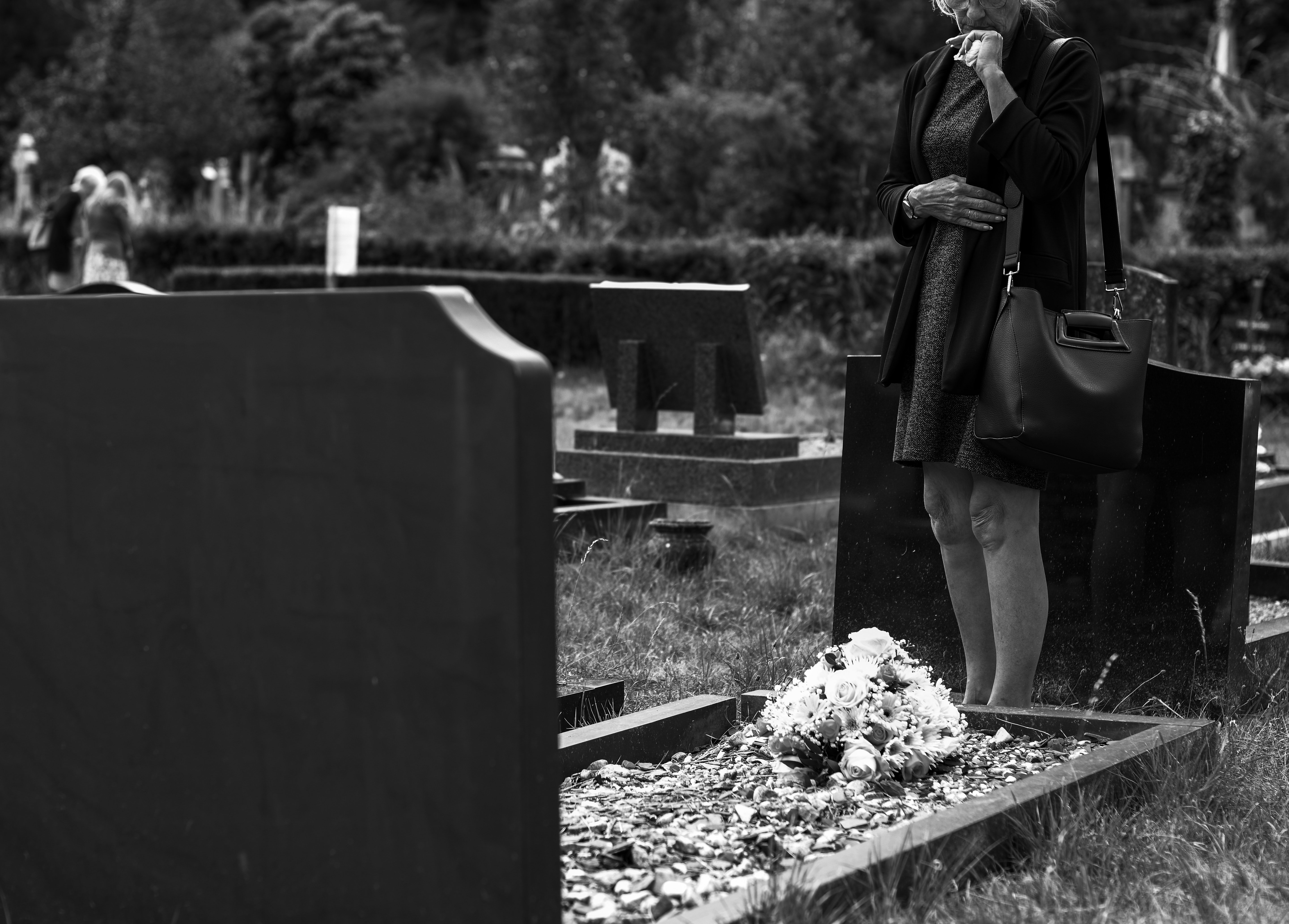 Mujer visita tumba en cementerio. | Foto: Pexels
