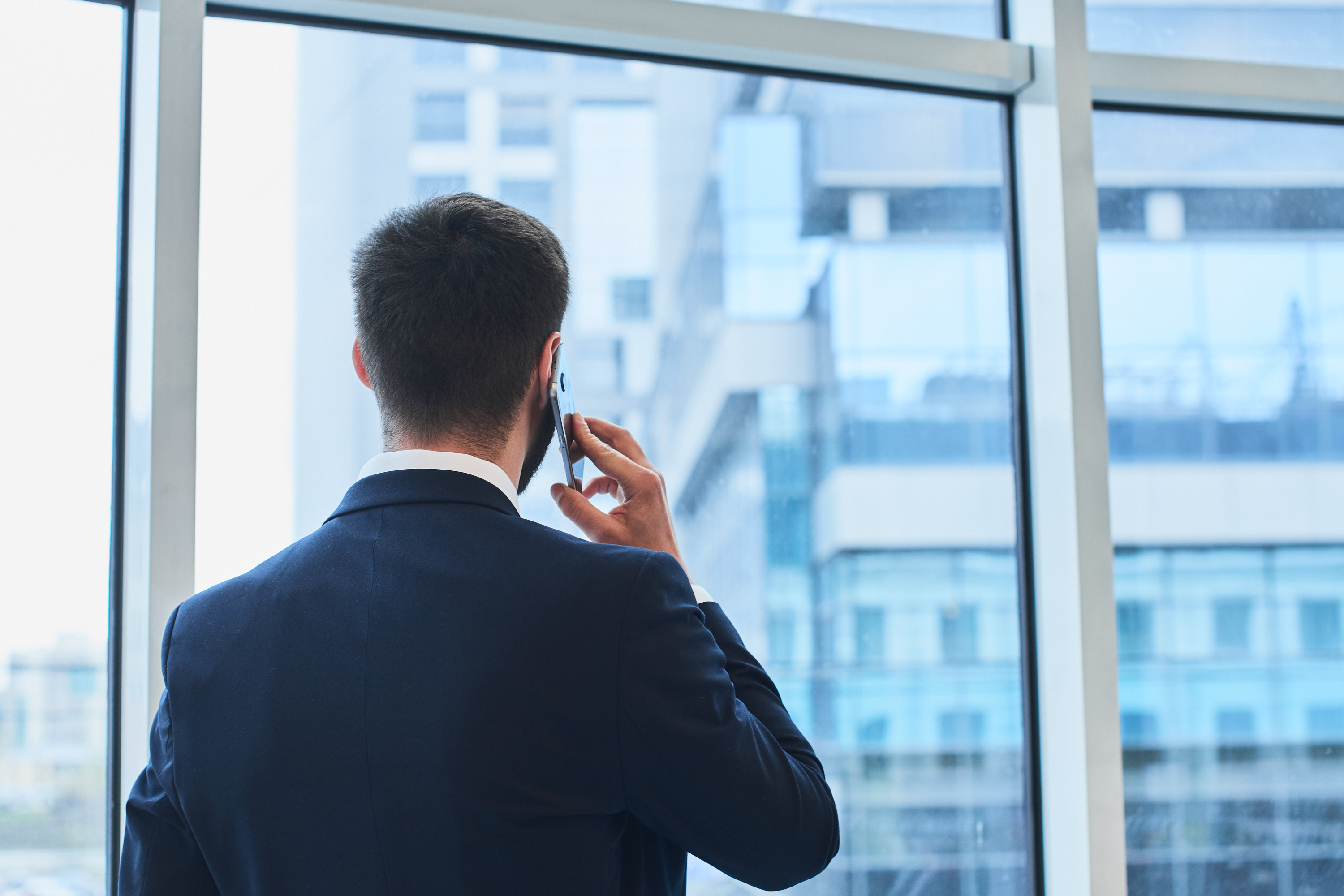 Hablando por el móvil y mirando por la ventana. | Fuente: Shutterstock