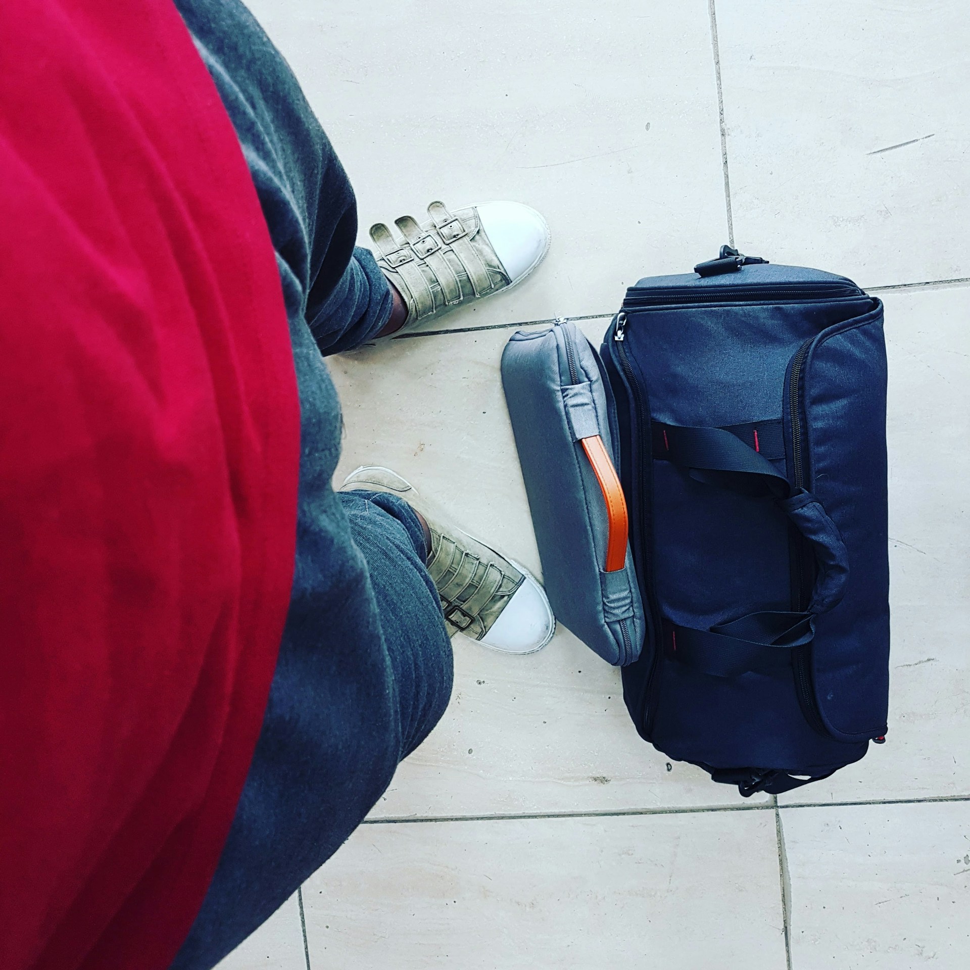 Una bolsa de viaje a los pies de alguien | Fuente: Unsplash