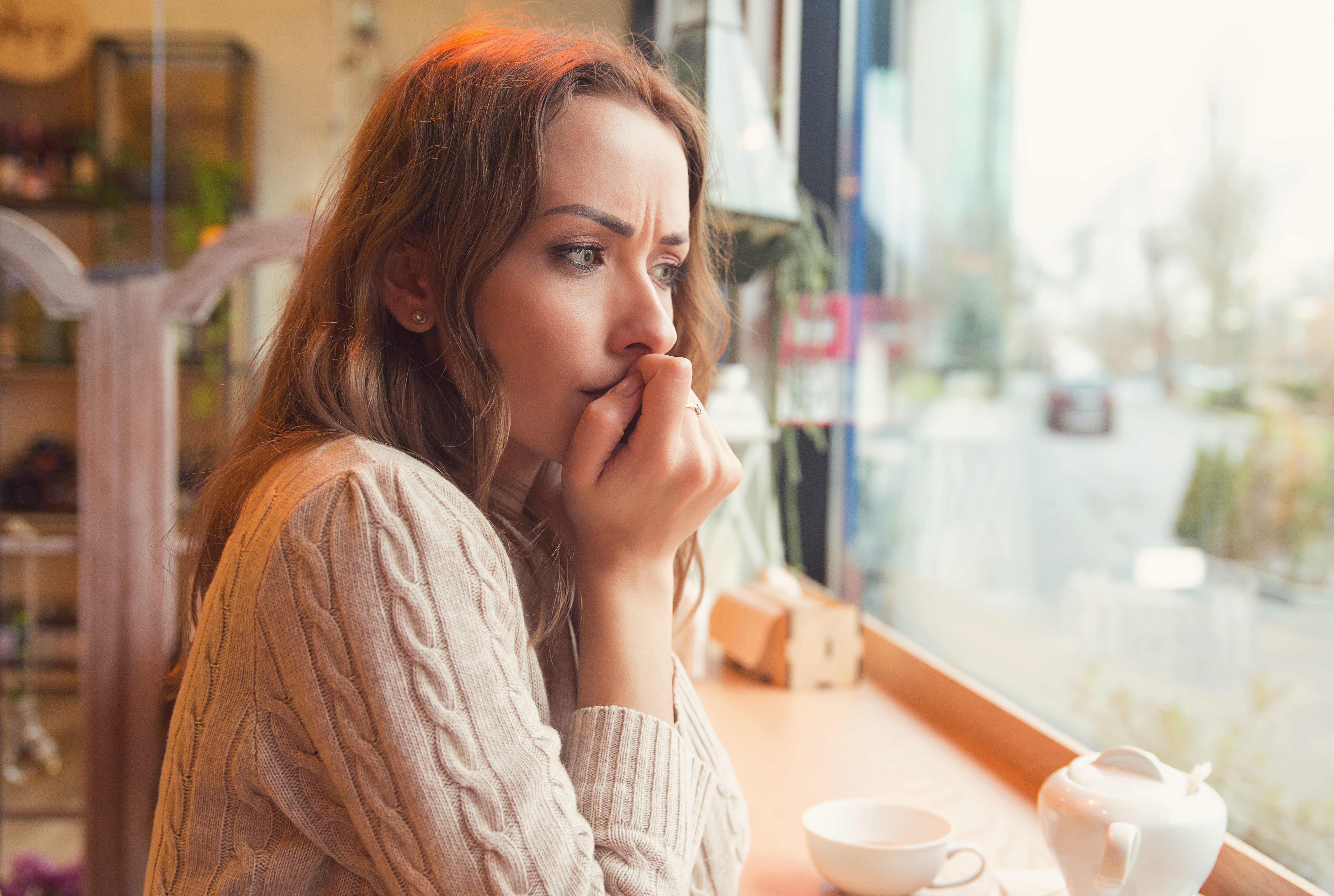 Una joven nerviosa en una cafetería | Fuente: Shutterstock