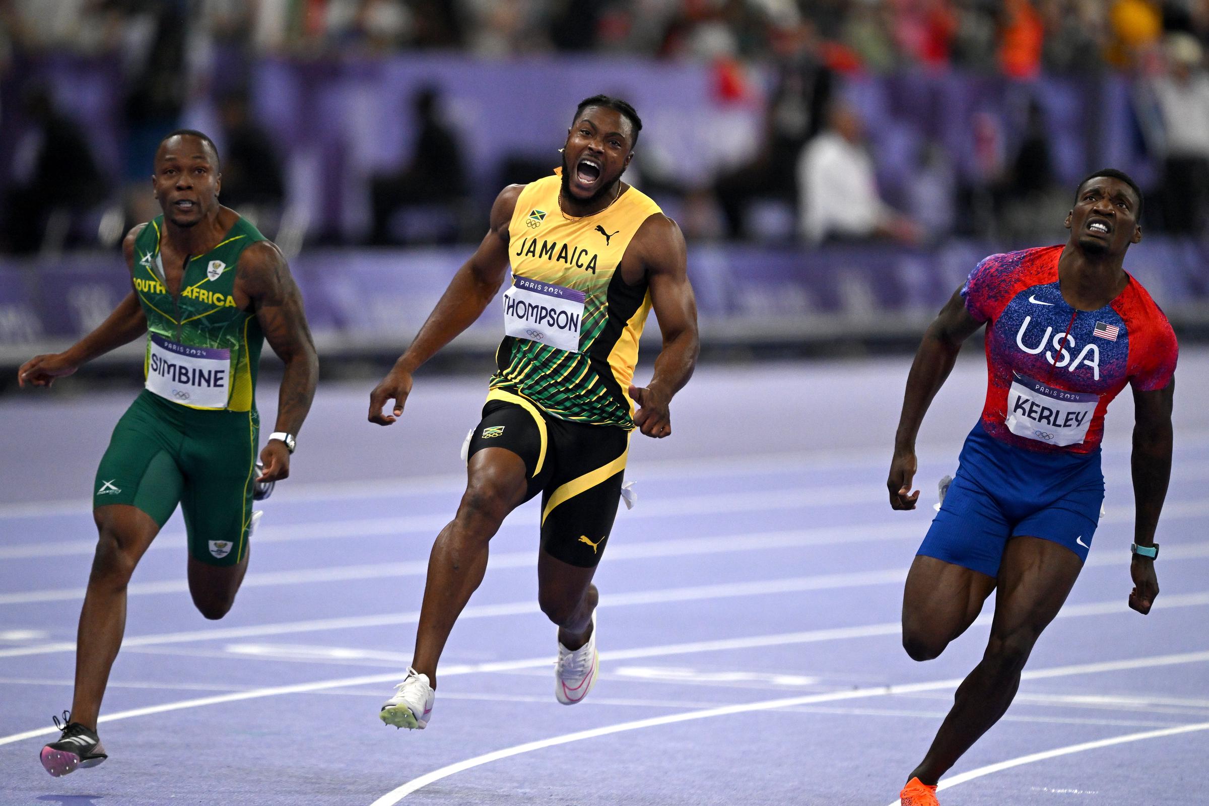 Kishane Thompson (c) reacciona tras la final masculina de los 100 metros planos durante el atletismo del noveno día de los Juegos Olímpicos de París 2024 en París, Francia, el 4 de agosto de 2024 | Fuente: Getty Images