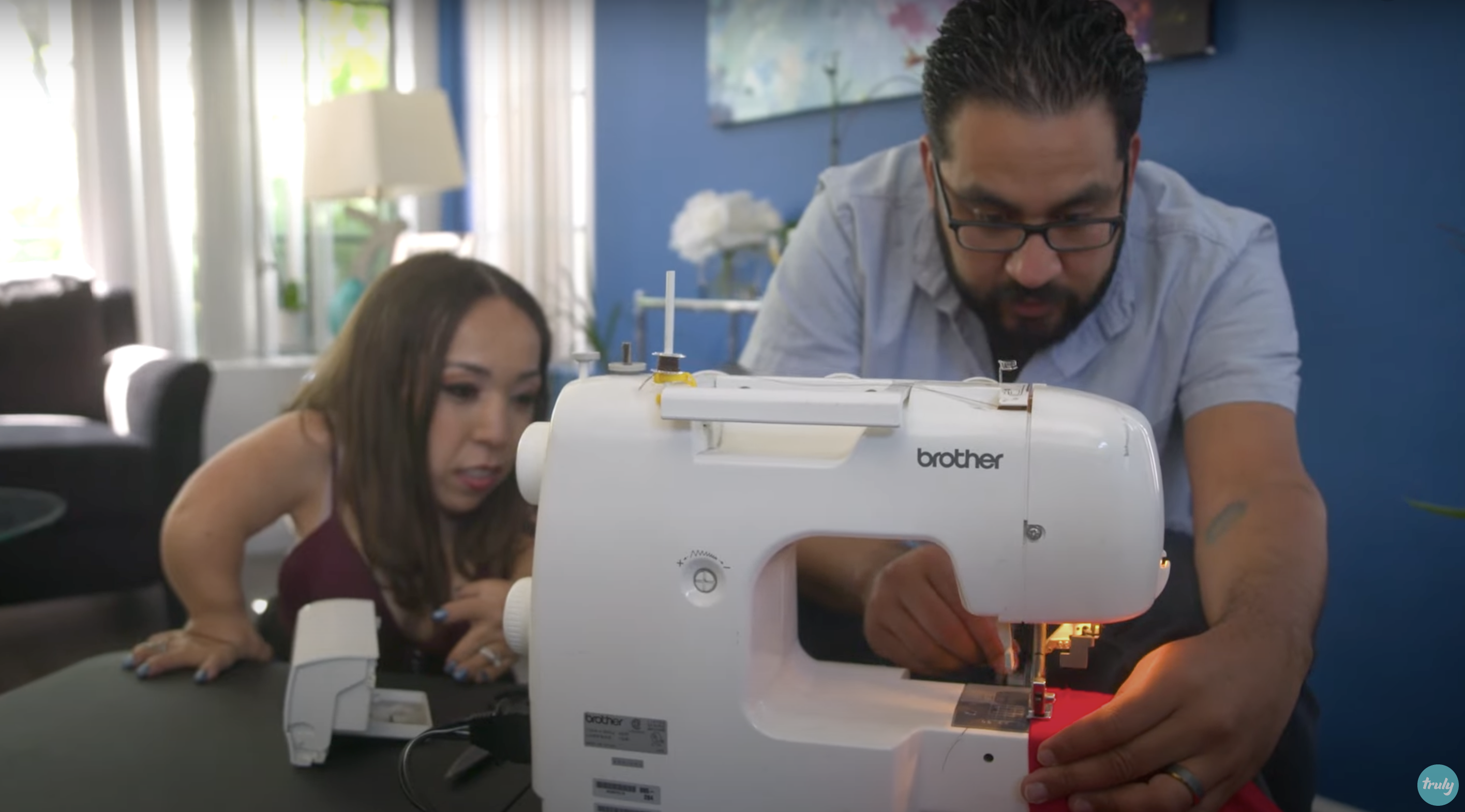 Bryan utiliza una máquina de coser para hacer arreglos en la camisa de Yesi | Foto: Youtube.com/Truly