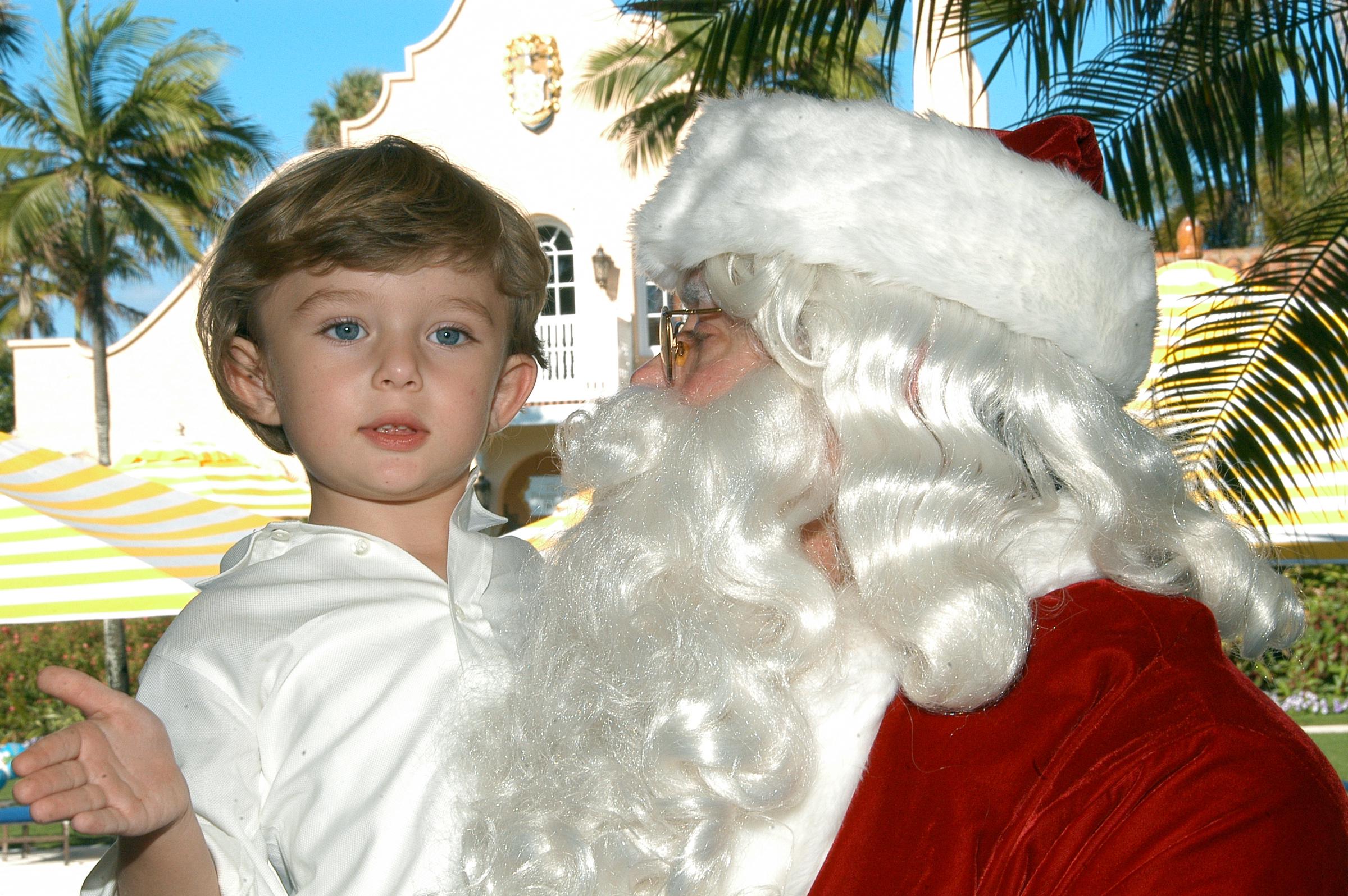Barron Trump es llevado en brazos por Papá Noel el día de Navidad en la finca Mar-a-Lago en Palm Beach, Florida, 25 de diciembre de 2008. | Fuente: Getty Images