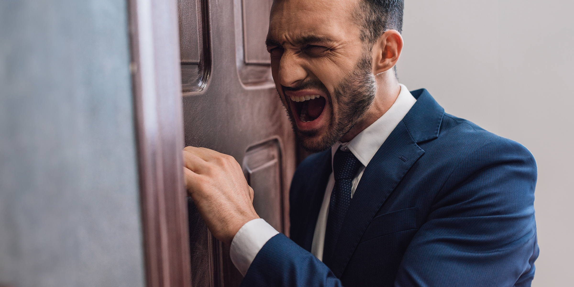 Un hombre enfadado llamando a una puerta | Fuente: Shutterstock