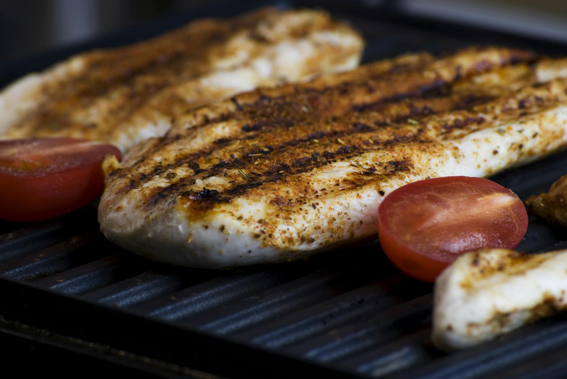 Rodajas de carne y tomates en una parrilla | Fuente: Pexels