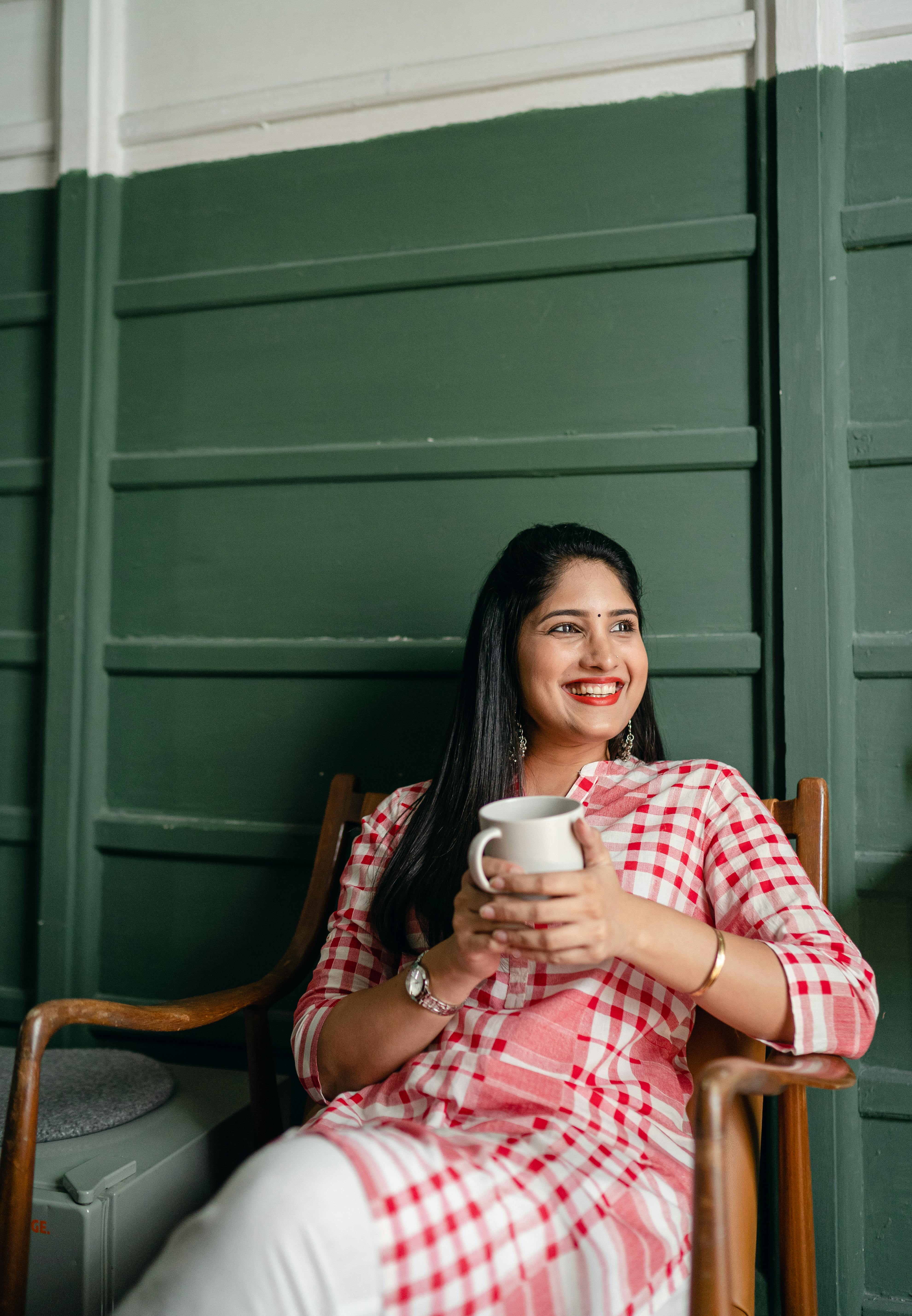 Una mujer feliz sosteniendo una taza | Fuente: Pexels