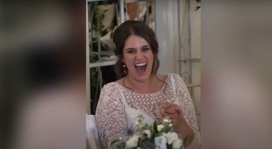 La recién casada Katie riendo durante el discurso de su marido | Fuente: YouTube / Daily Record