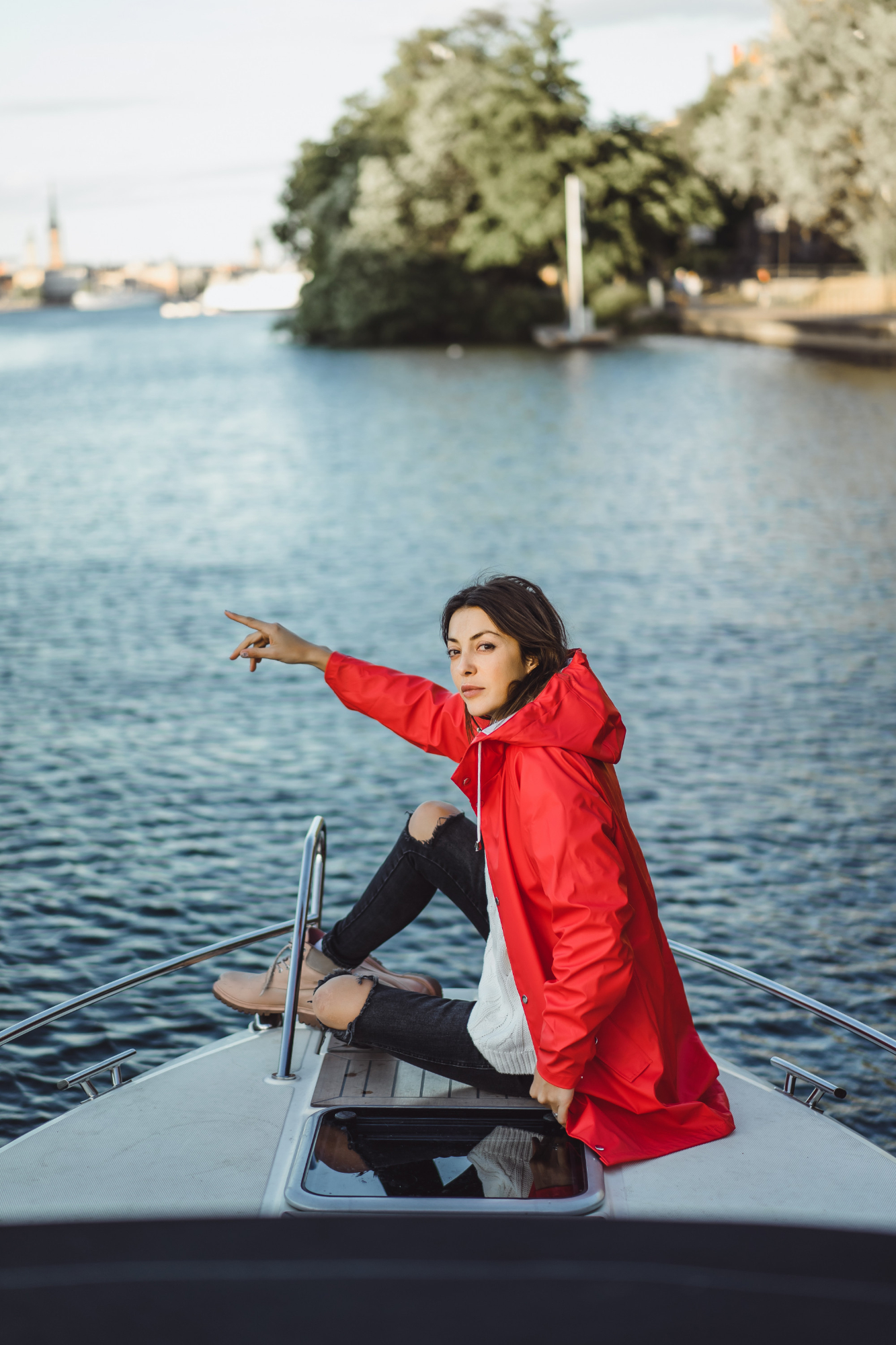 Mujer con la mano estirada por la borda de un barco | Fuente: Freepik