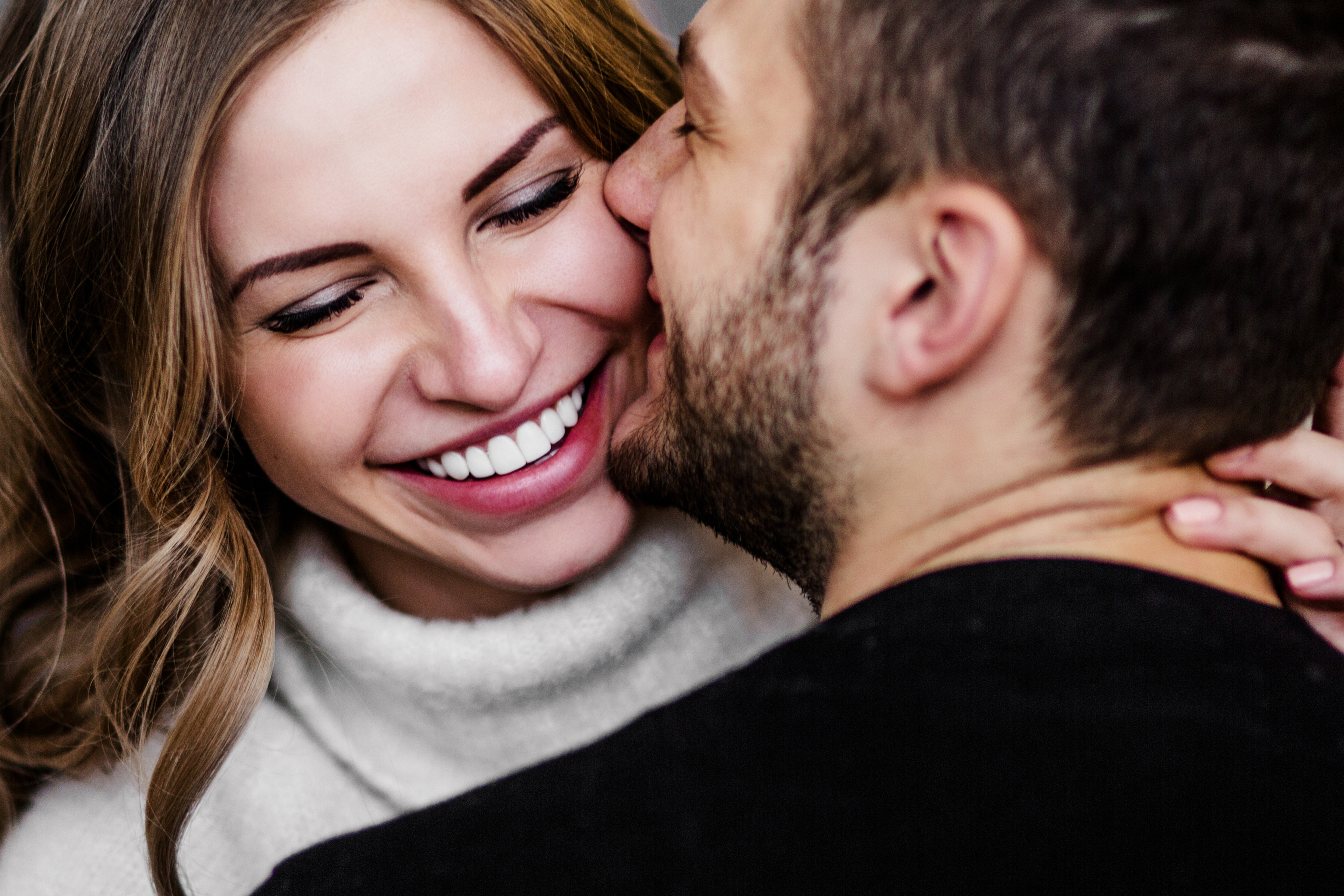 Un hombre besa a su pareja en la mejilla | Fuente: Shutterstock