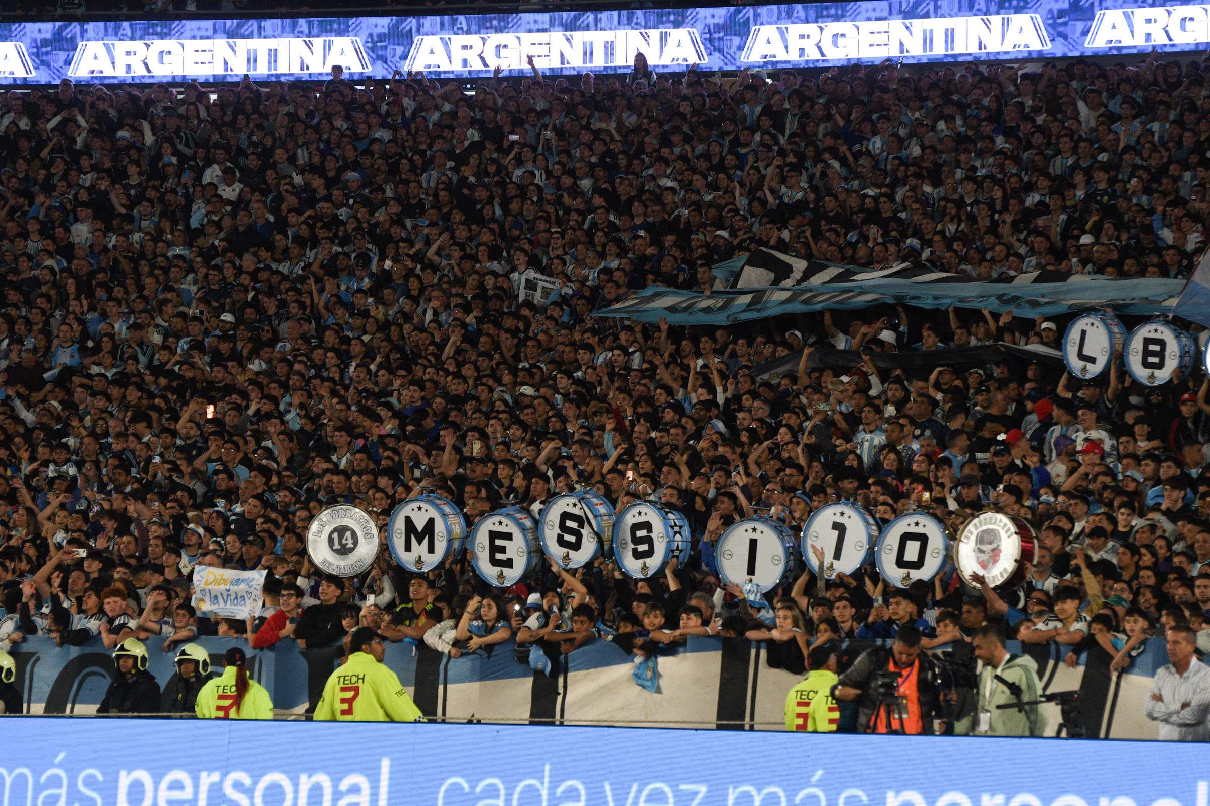 Una multitud de aficionados colmó las tribunas del estadio durante el encuentro entre Argentina y Benín, celebrado el 6 de octubre de 2026 en Buenos Aires, Argentina. En medio del fervor y los cánticos de la hinchada albiceleste, un grupo de seguidores levantó bombos decorados que formaban el nombre "MESSI 10" para homenajear a Lionel Messi en la última vez que vistió la camiseta nacional tras anunciar su retiro internacional. | Fuente: Getty Images