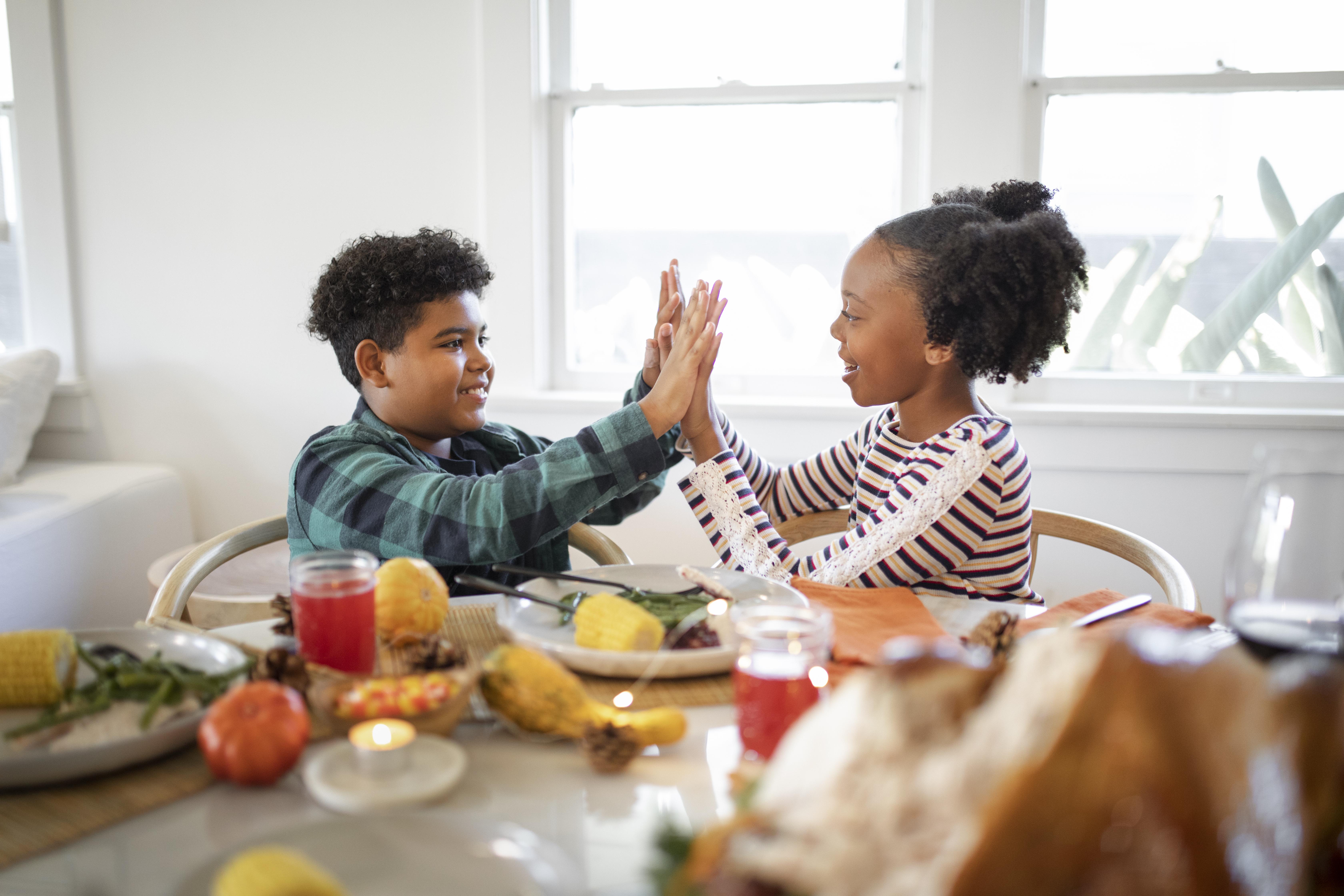 Dos niños jugando en la mesa del comedor | Fuente: Freepik
