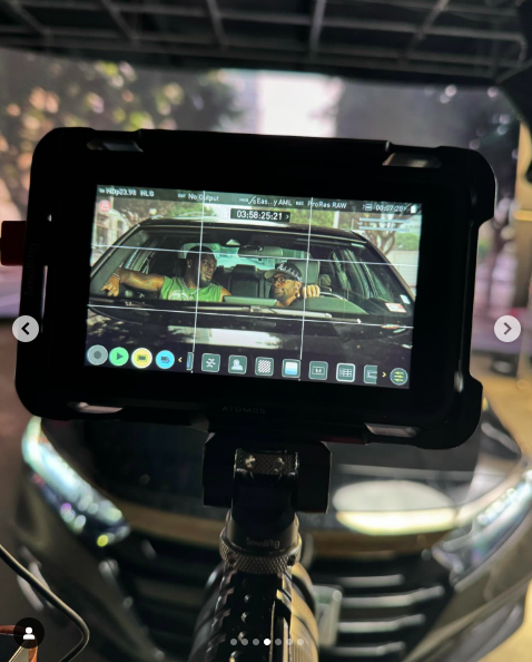 Un monitor de cámara que muestra a dos actores mirándose desde el interior de un automóvil. | Fuente: Instagram/alyshaburney_