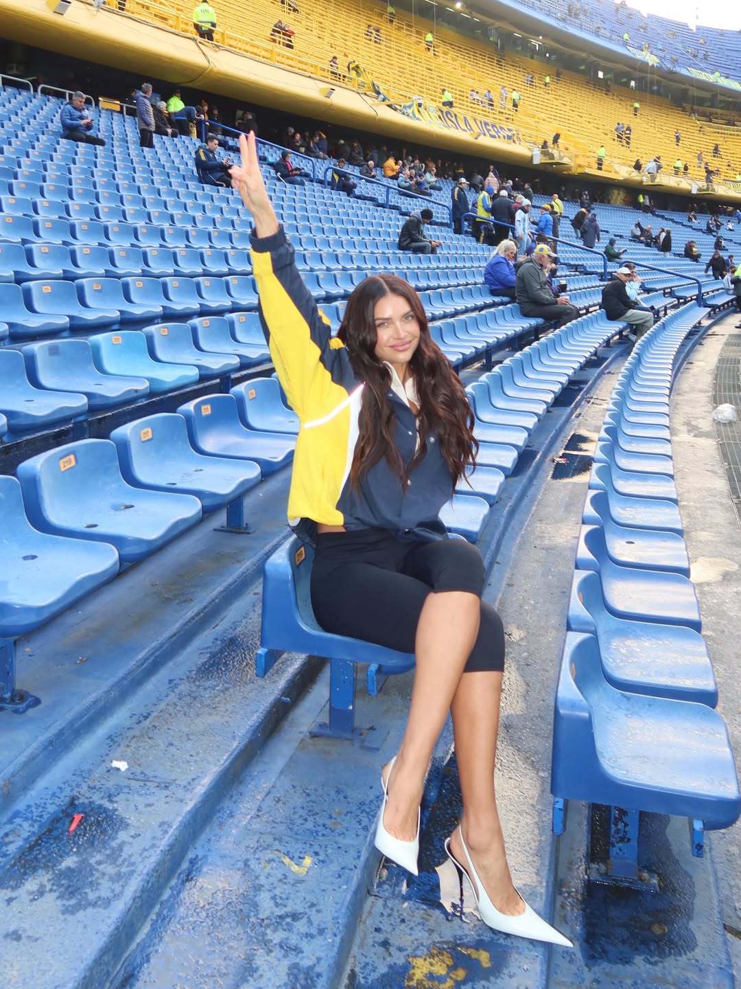 Zaira Nara posa en una de las tribunas de La Bombonera con un look deportivo combinado con stilettos blancos durante su visita al estadio de Boca Juniors. | Fuente: Instagram/zaira.nara