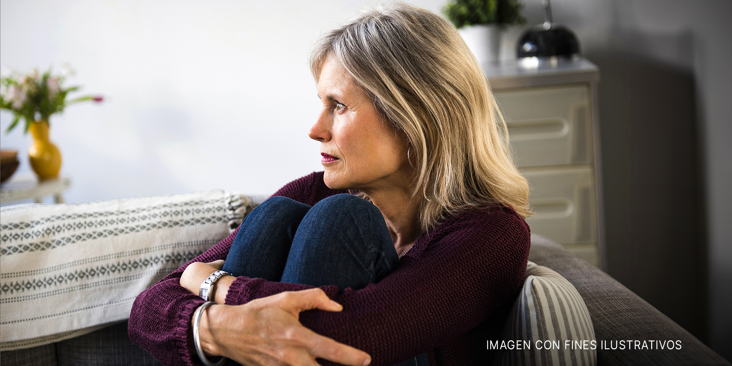 Una mujer sentada en el sofá con aspecto triste | Foto: Shutterstock