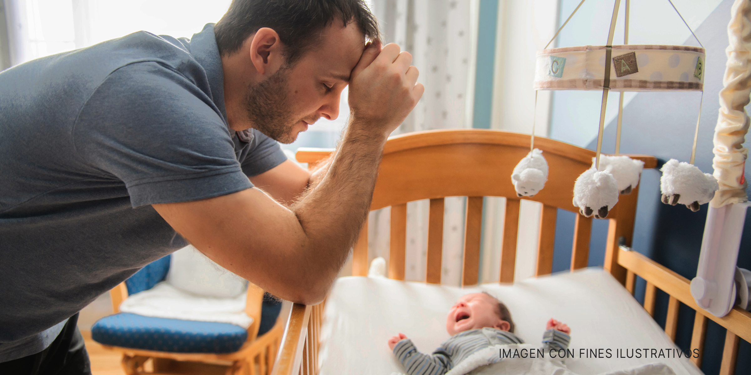 Hombre y bebé en su cuna | Foto: Shutterstock