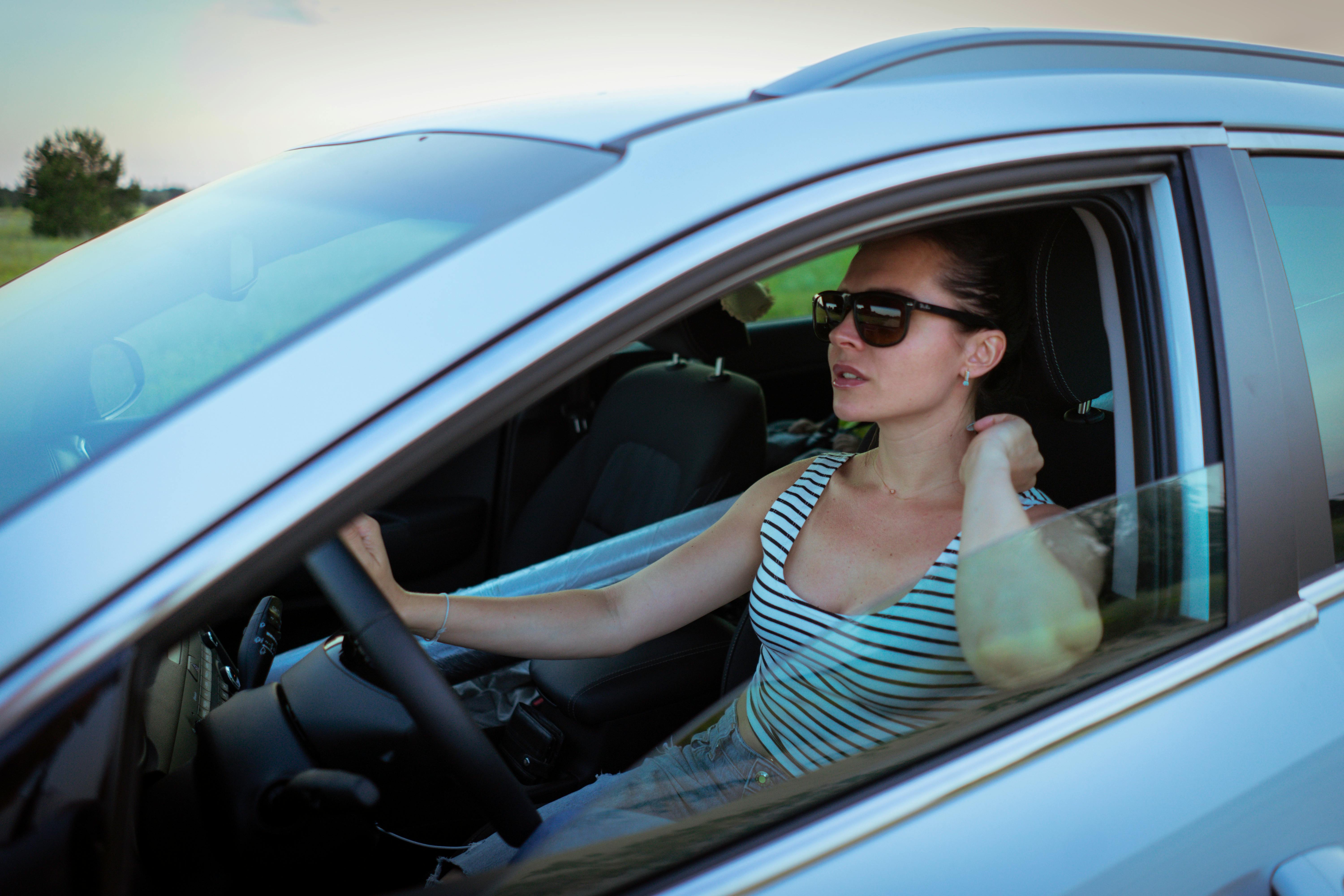 Una mujer conduciendo con gafas de sol | Fuente: Pexels