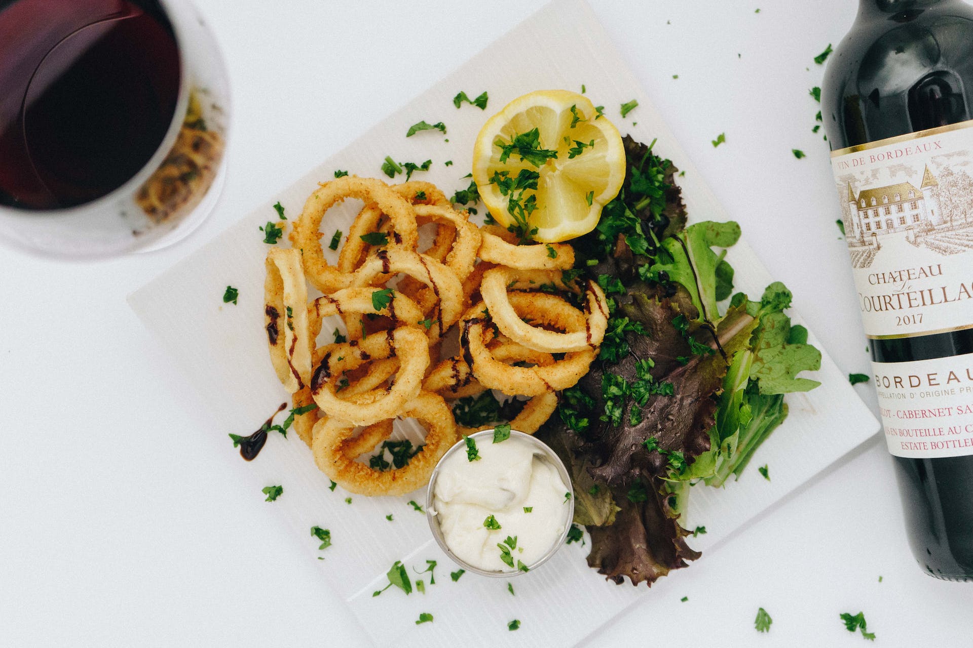 Calamares con ensalada y vino. | Fuente: Pexels