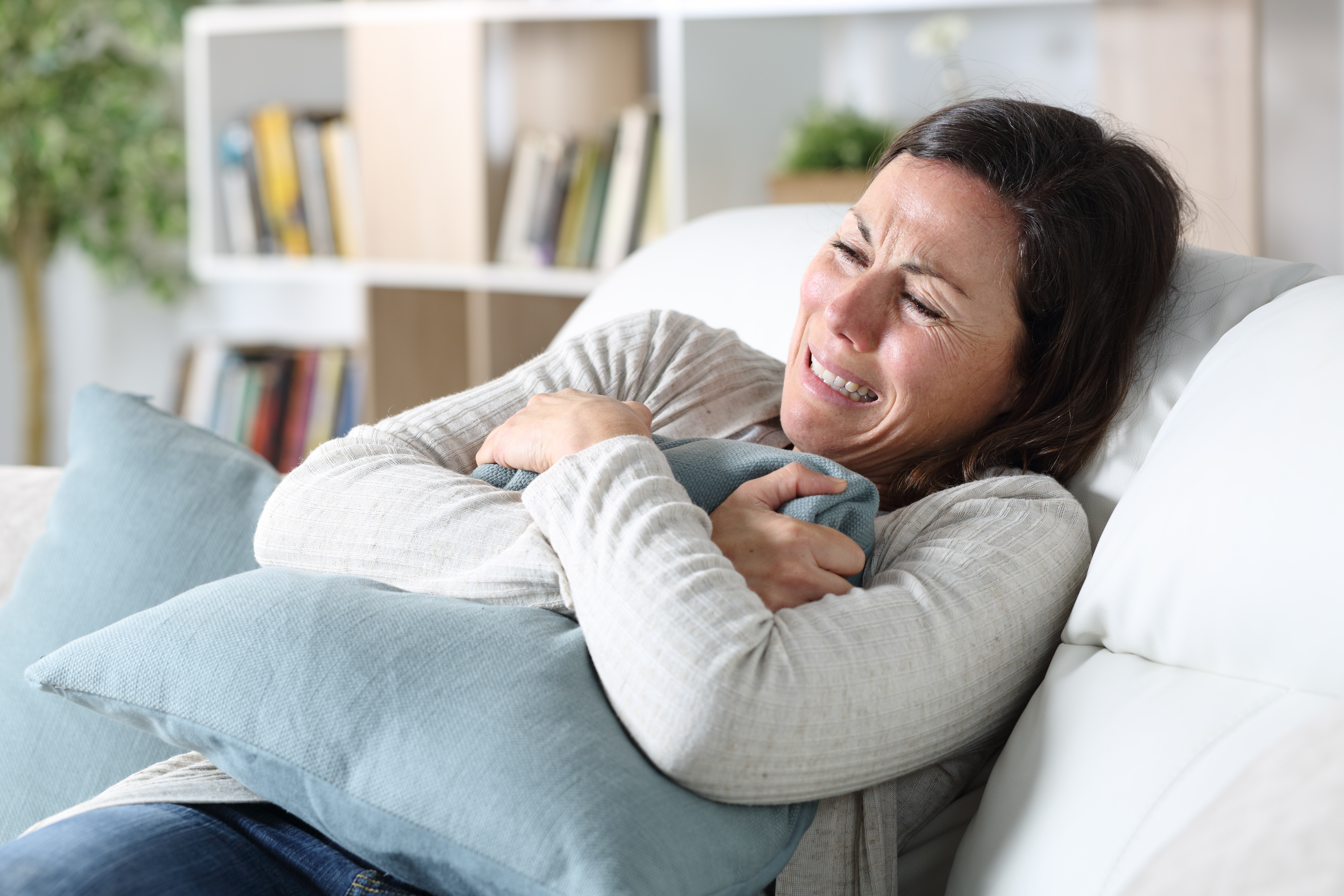 Mujer triste llora en casa | Fuente: Shutterstock.com