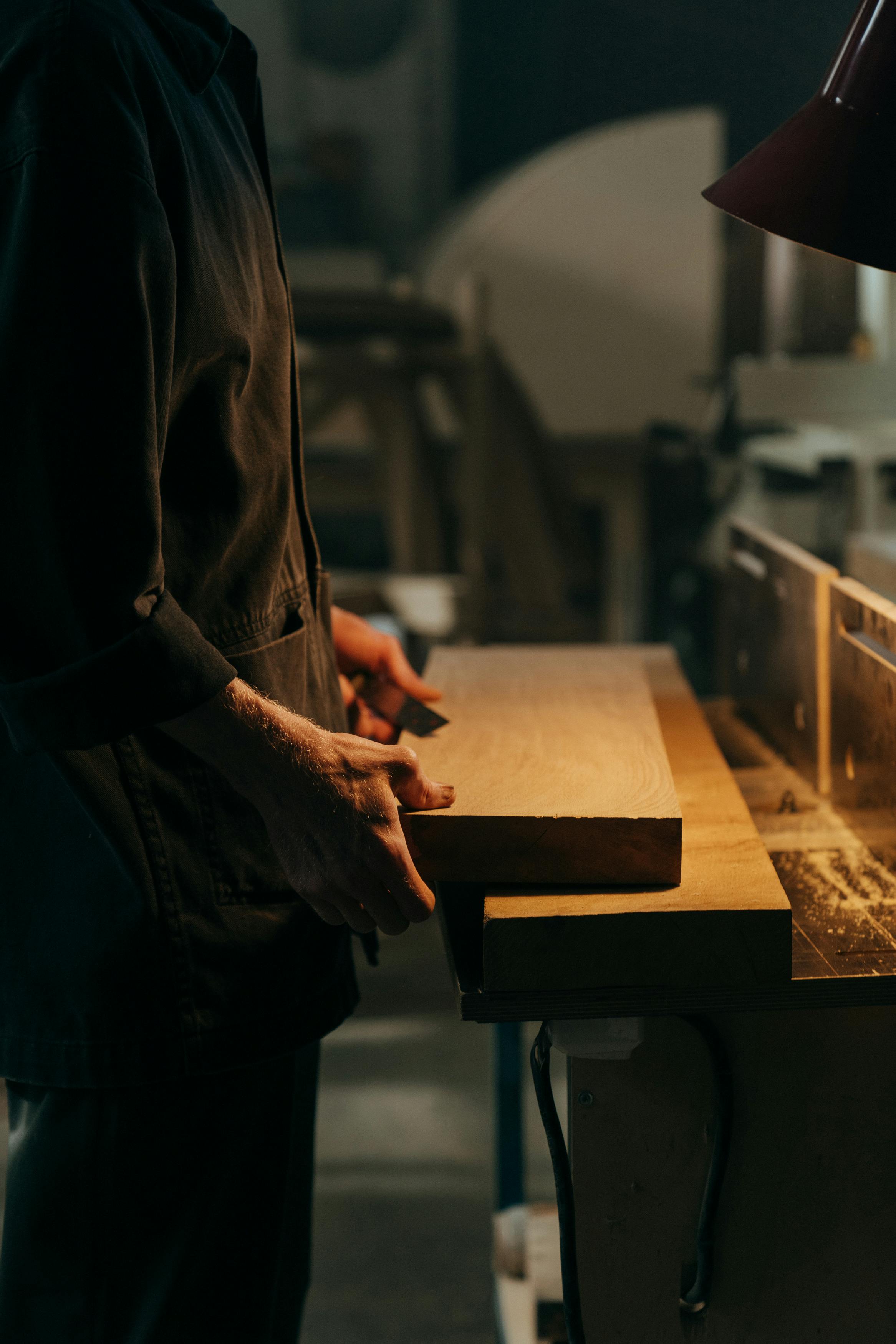 Un hombre sujetando paneles de madera | Fuente: Pexels