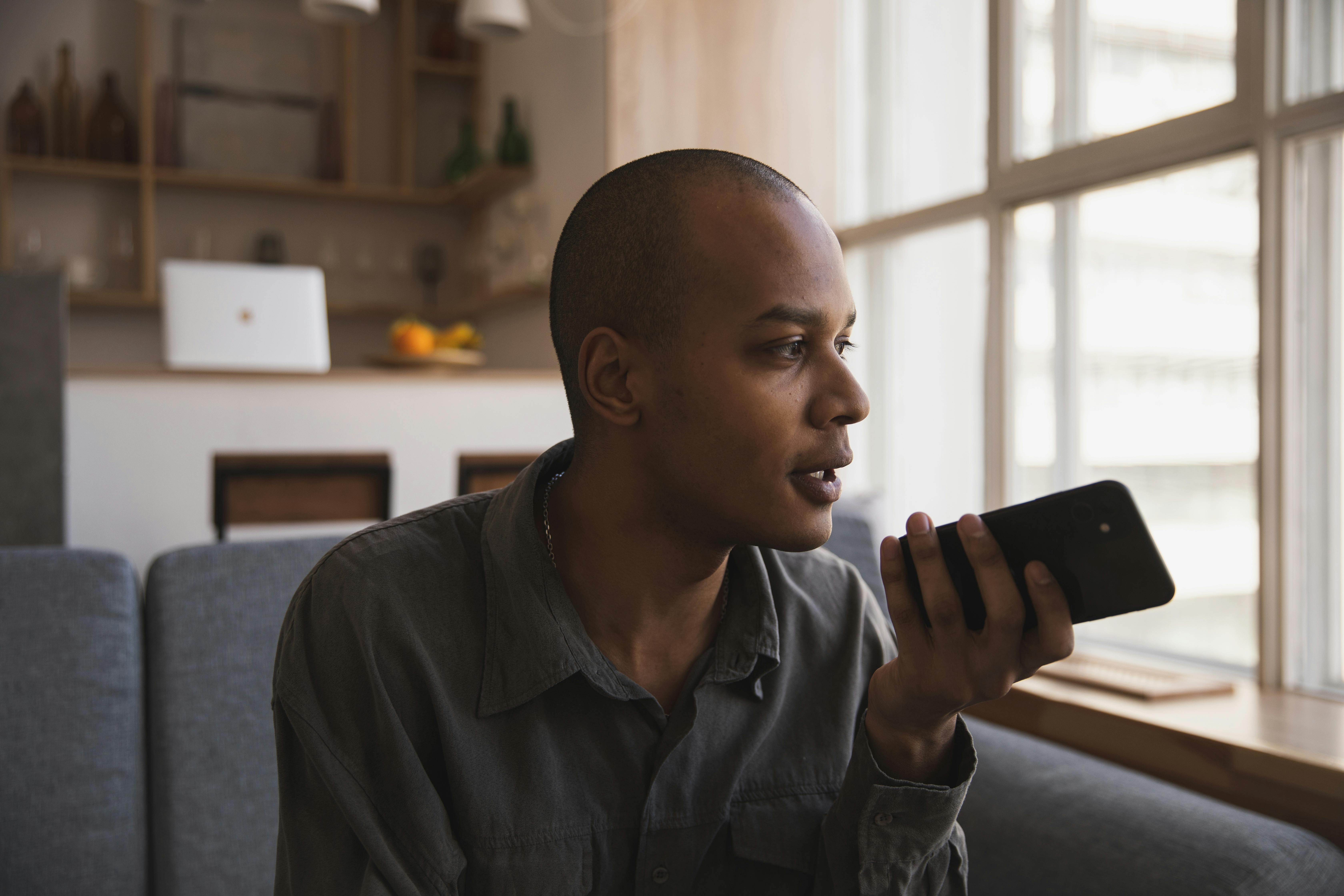 Un hombre hablando por el altavoz de su teléfono | Fuente: Pexels