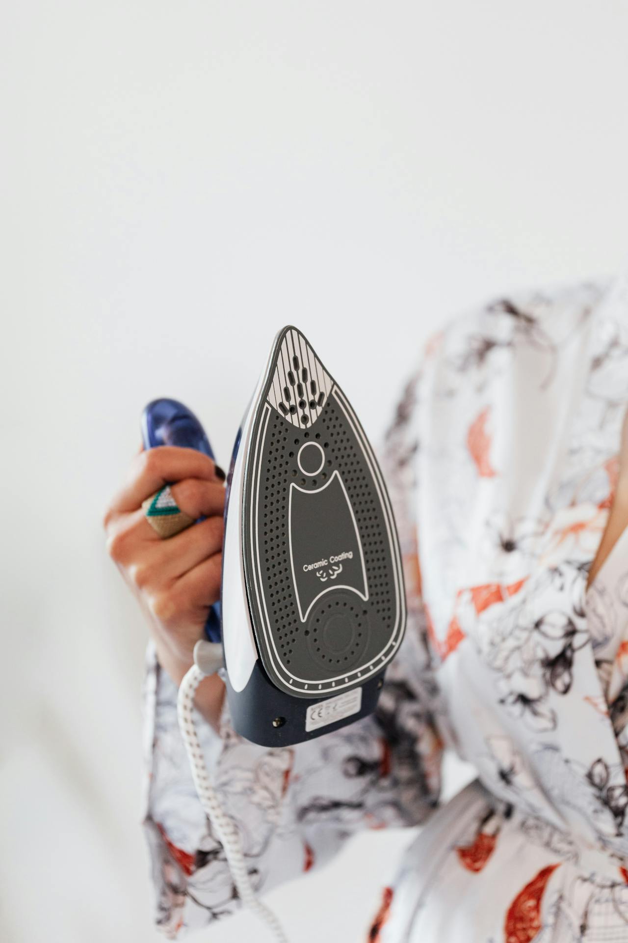 Una mujer sujetando una plancha de vapor | Fuente: Pexels