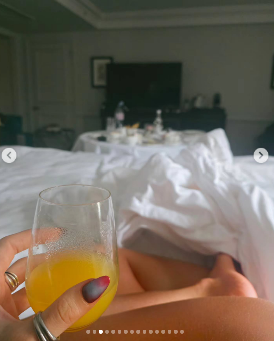 Emilia Attias retrató una tranquila mañana de descanso desde la cama de su habitación de hotel, sosteniendo una copa con jugo de naranja en primer plano. La imagen en perspectiva subjetiva deja ver las sábanas blancas deshechas y, al fondo de la estancia, una mesa servida con el desayuno. | Fuente: Instagram/emilia_att